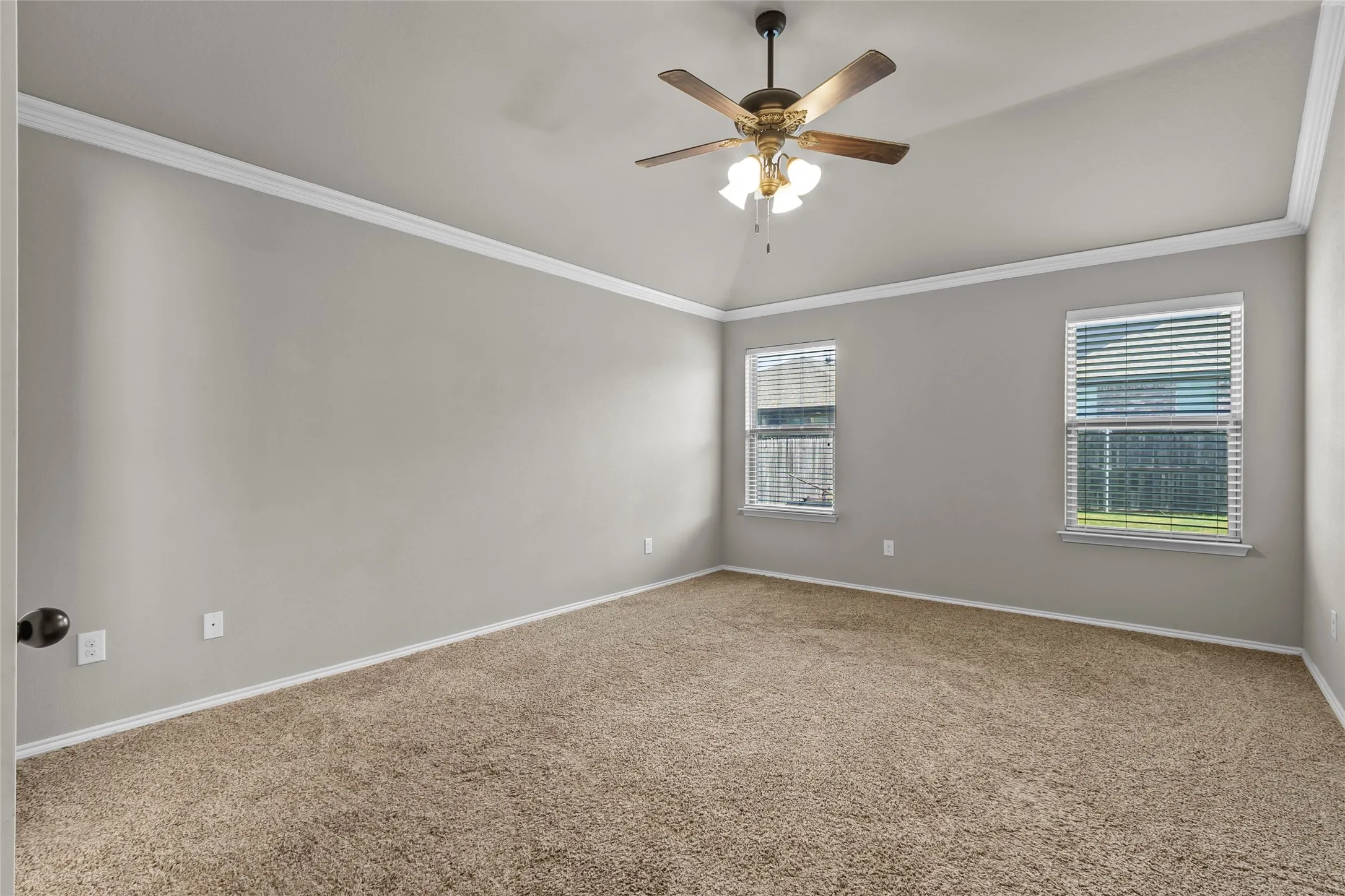 Spacious room featuring vaulted ceilings, neutral wall tones, and plush carpeting
