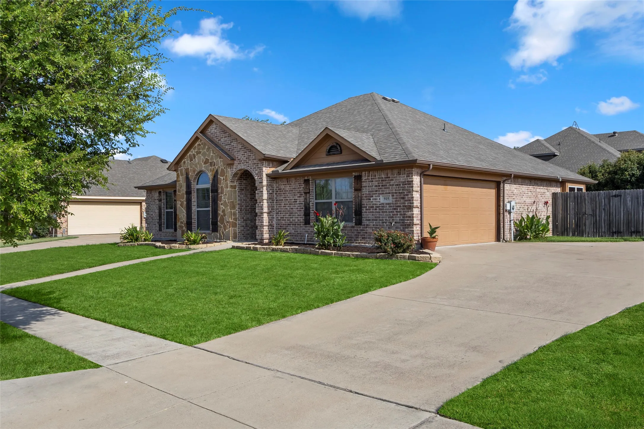 Brick and stone exterior featuring an arched entryway and dark-shuttered windows