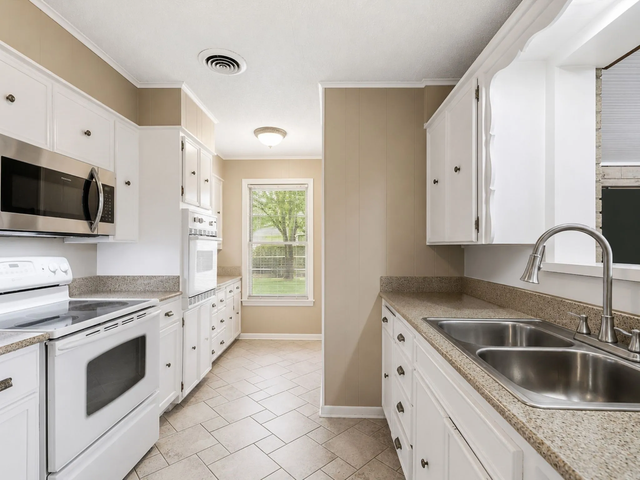 The centrally located kitchen offers abundant cabinetry, generous prep space, and an easy flow into both dining areas and multiple living spaces.