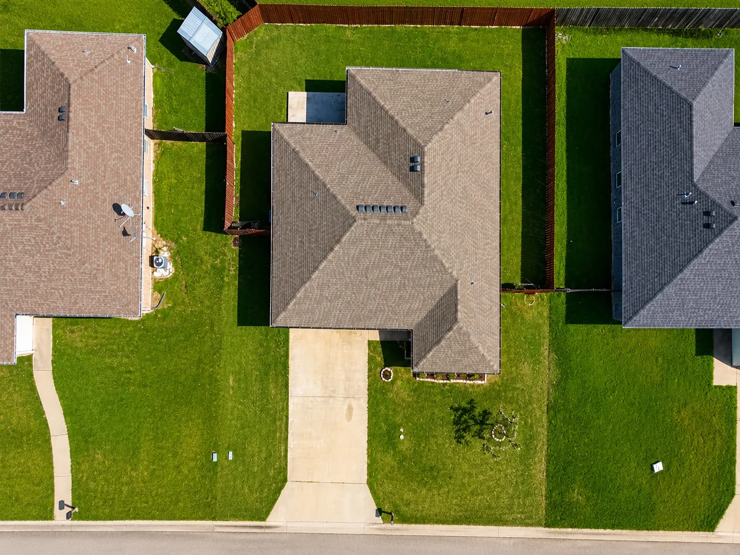 Property featuring a large, manicured lawn with mature privacy fencing