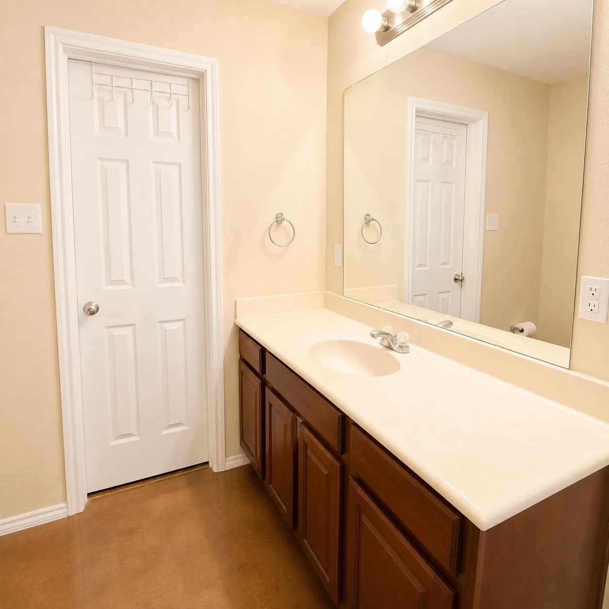 Bathroom featuring a dark wood-finish vanity with a light-toned countertop, an integrated sink, and chrome fixtures