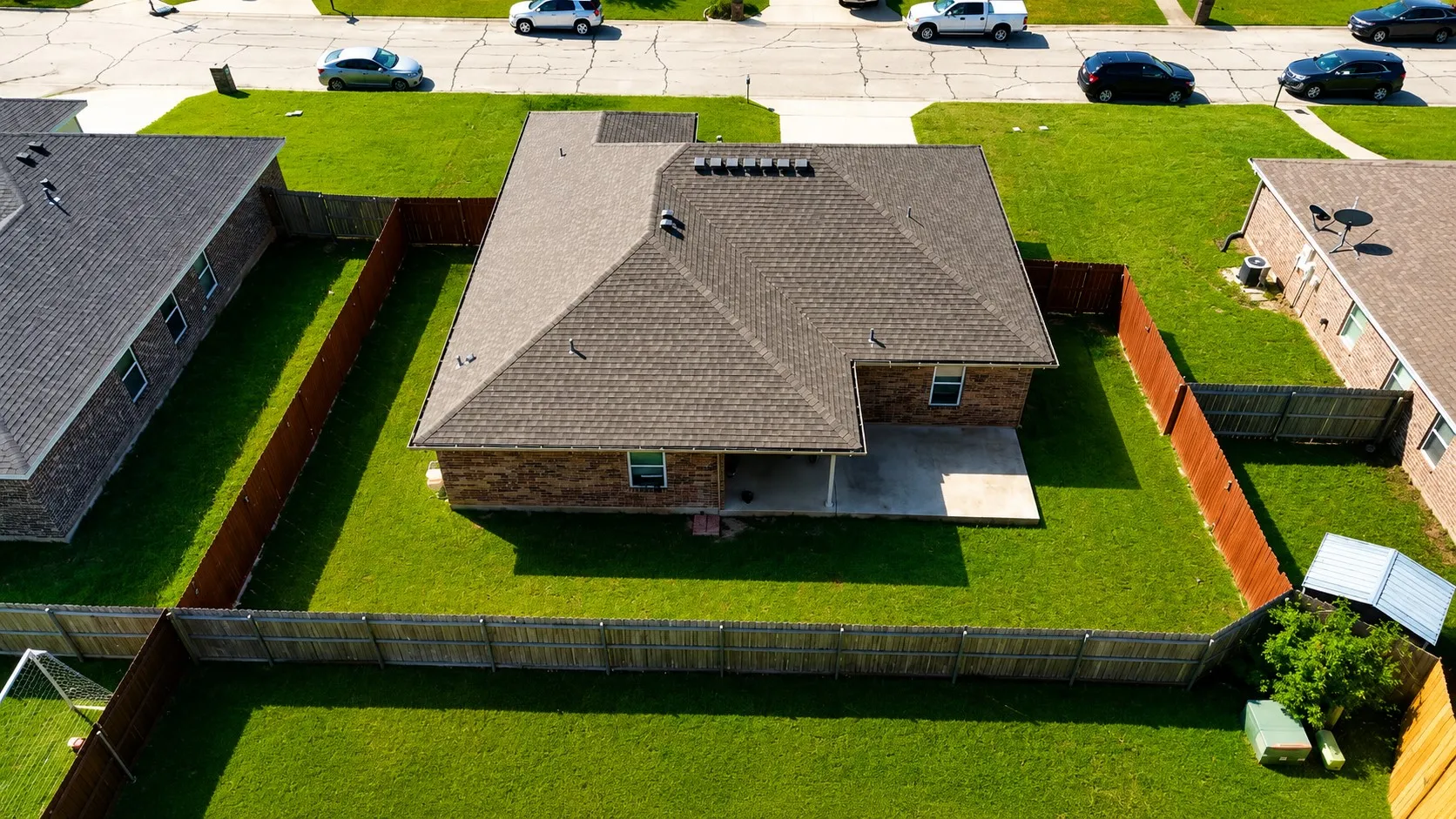Private backyard featuring a concrete patio, wood fencing, and a manicured lawn