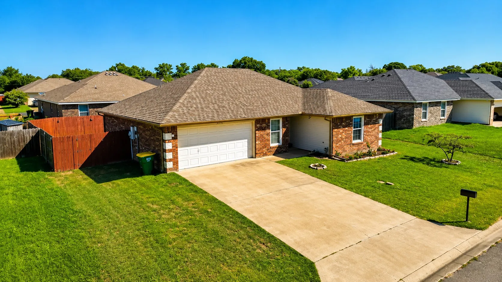 Single-story residence featuring a brick exterior with stone accents, a two-car garage, and a concrete driveway