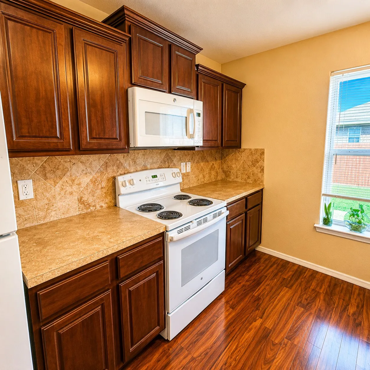 Kitchen featuring rich wood cabinetry, an integrated microwave, a white electric range, and laminate countertops