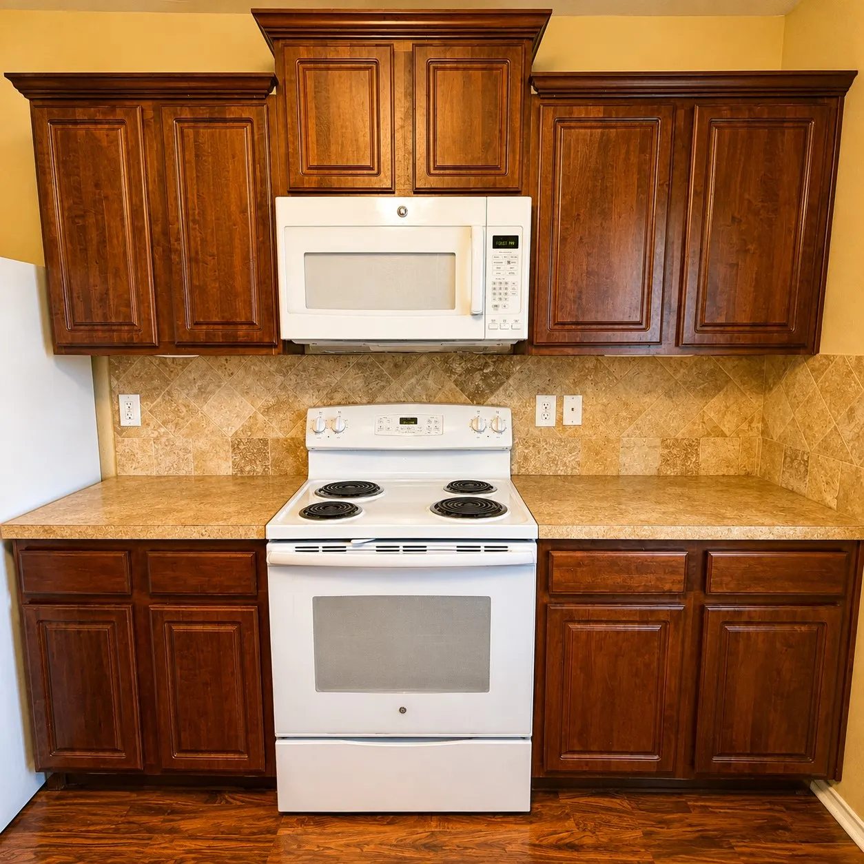 Kitchen featuring rich wood cabinetry, patterned tile backsplash, and light-toned countertops