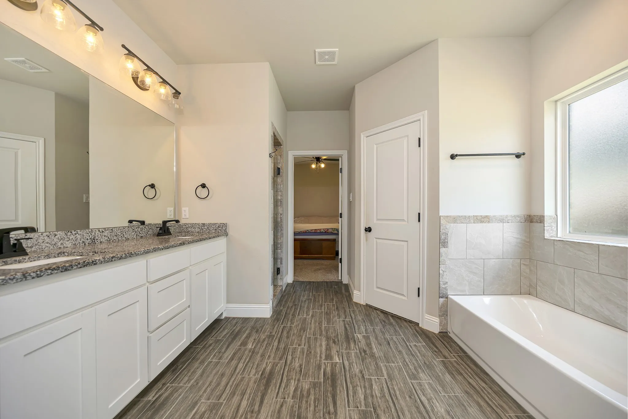 Spacious primary bath with granite counters.