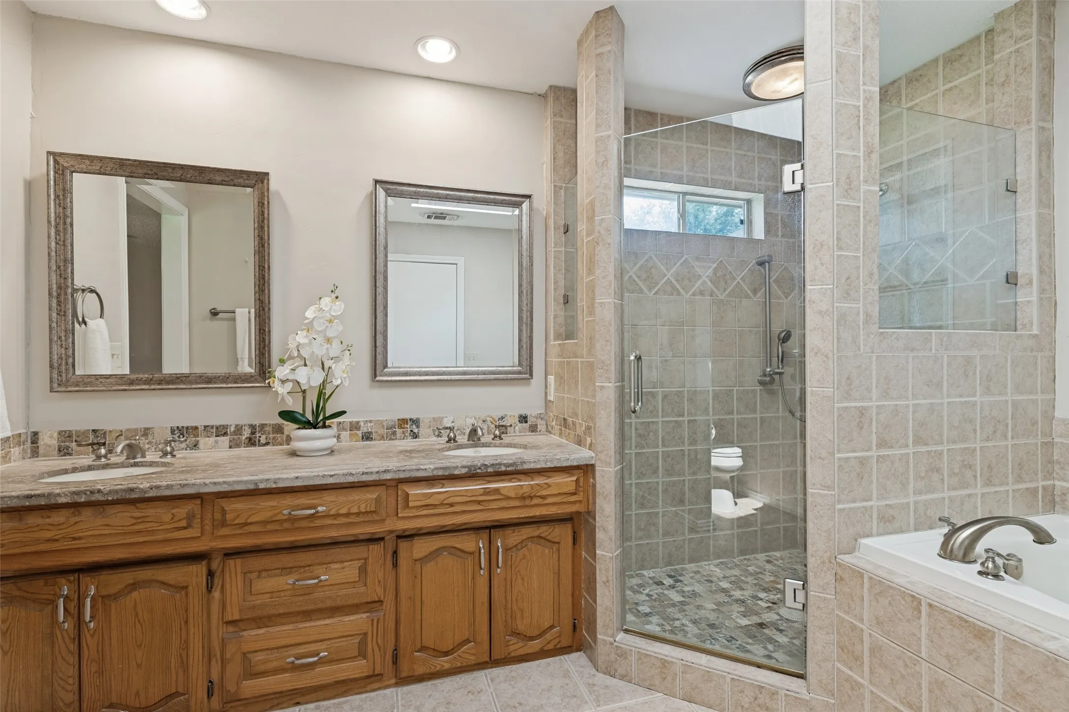 Large separate shower with beautiful glass door.