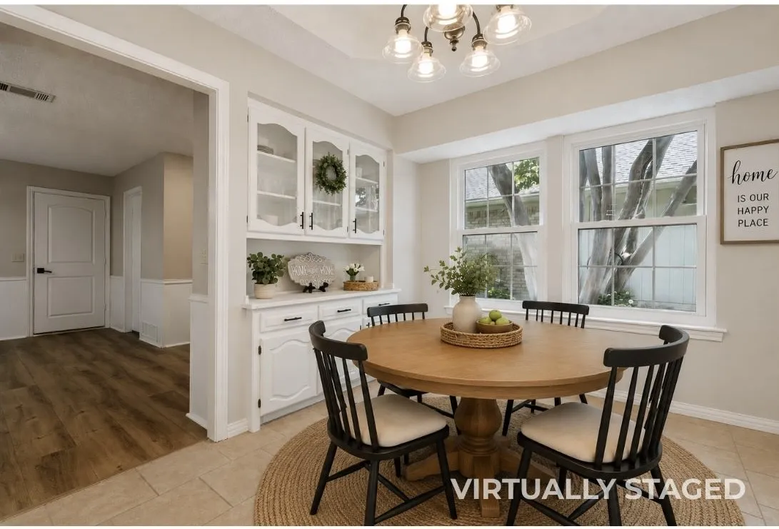 Built-in white cabinetry with glass-front doors, tray ceiling with a multi-light chandelier, and windows with tons of natural light.