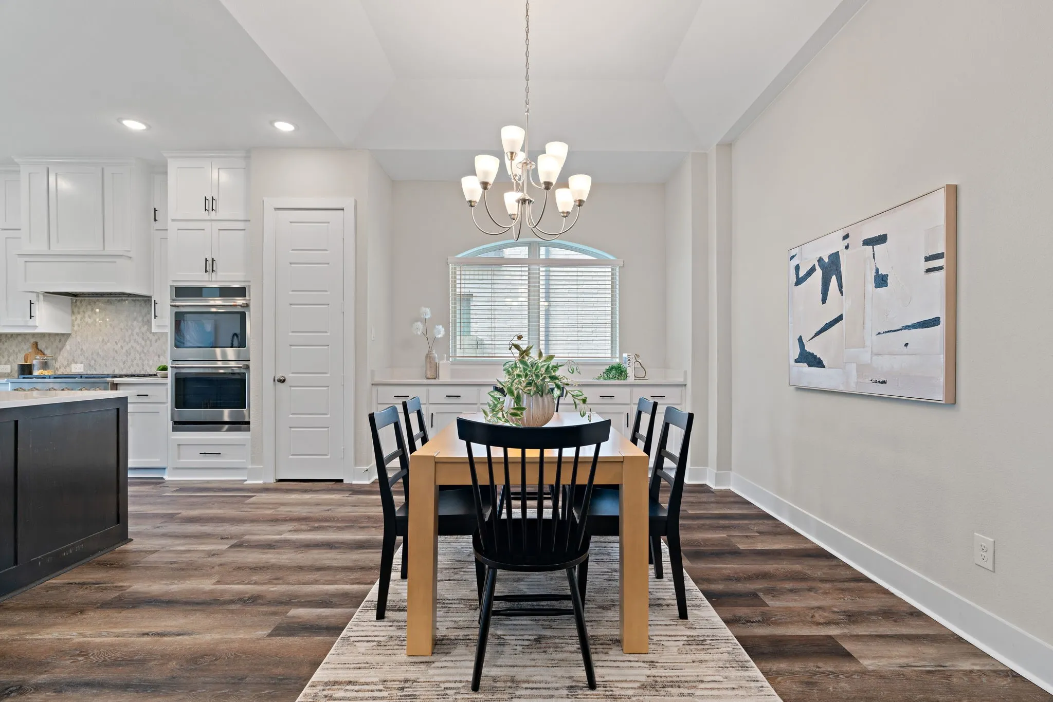 Open-concept living space with wood-finish flooring and a tray ceiling