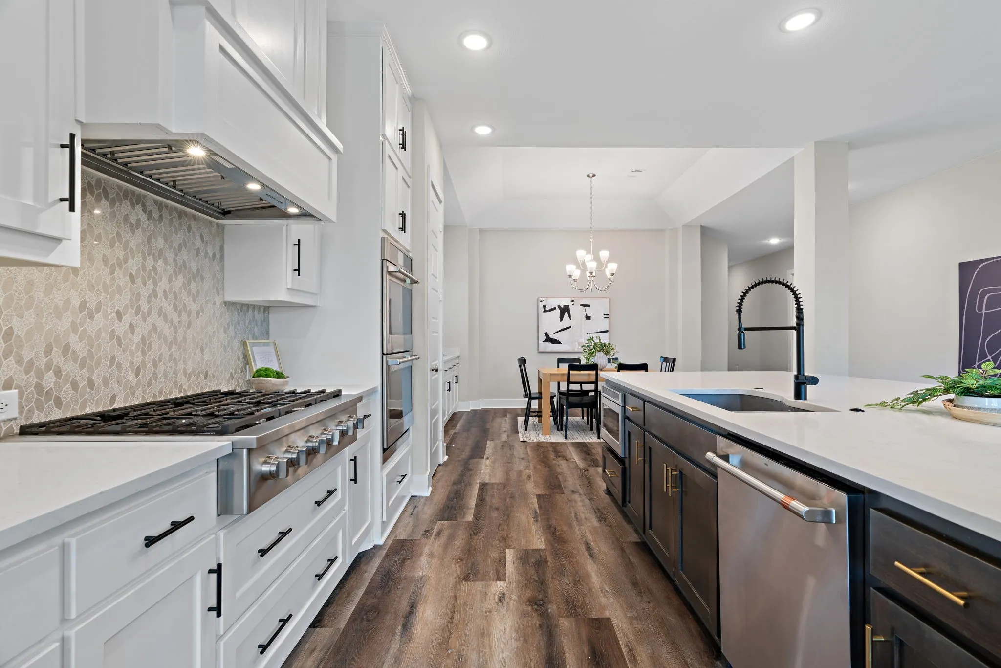Gourmet kitchen featuring a commercial-style range, light-toned backsplash, and white cabinetry