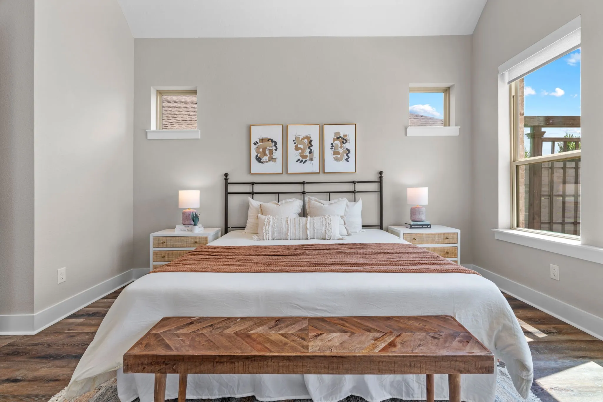 Spacious room featuring wood-finish flooring, light-toned walls, multiple windows, and crisp white trim