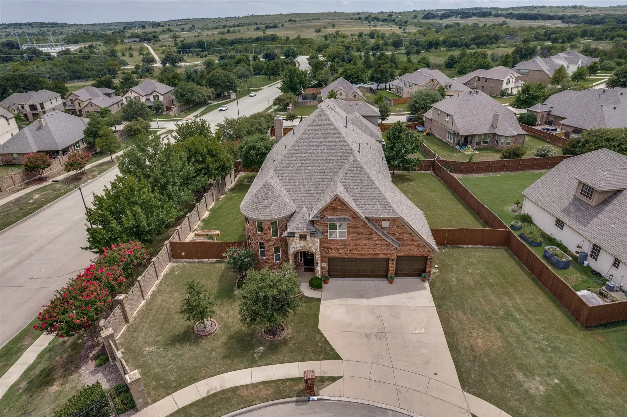 Sandlin custom-built home with over 3800 square feet located in a quiet community with easy access to I820, pitched architectural roof, expansive driveway, manicured lawn with mature landscaping, and brick detailing throughout the exterior facade