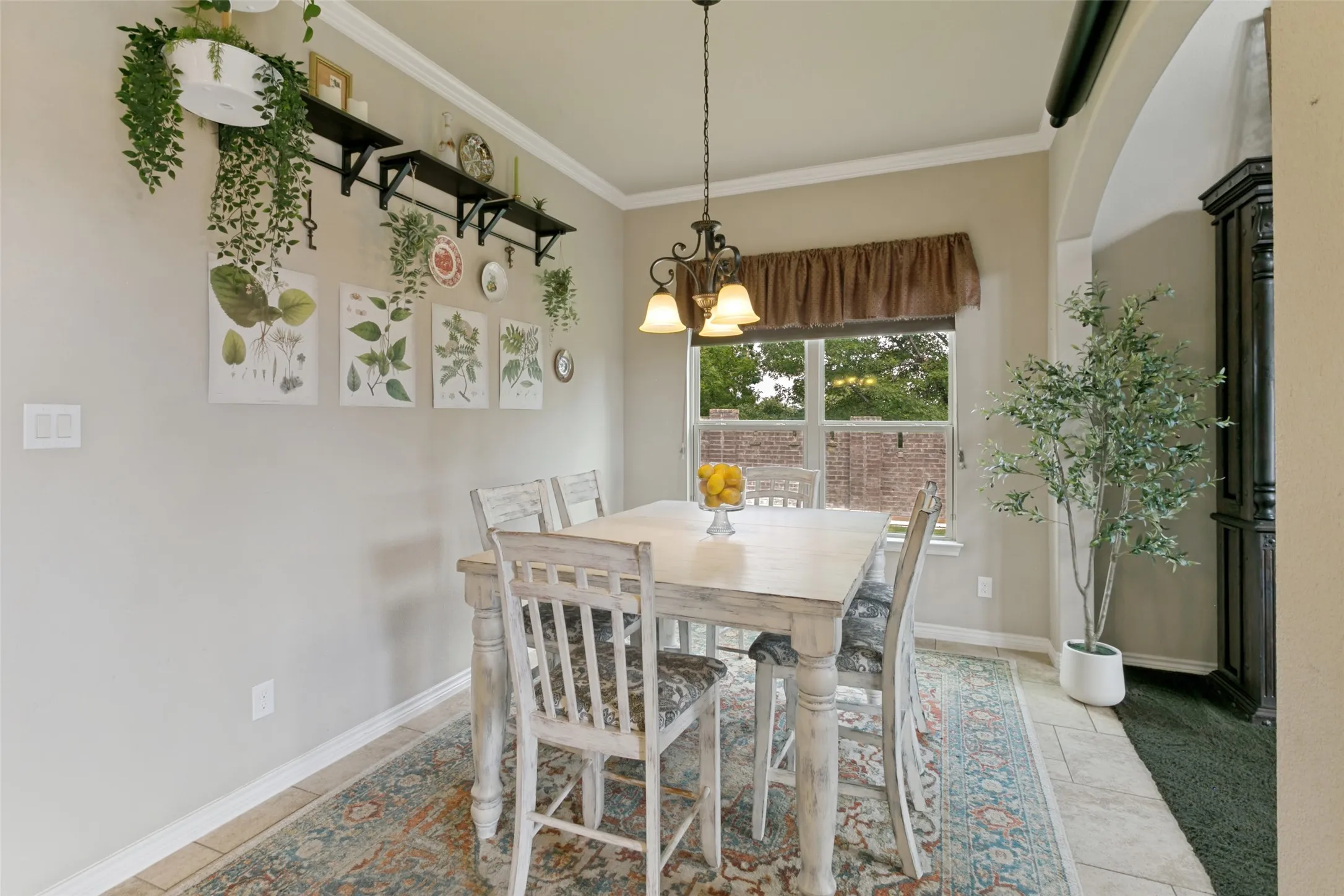 Bright Dining area bathed in natural light from dual windows, pendant lighting fixture, and neutral wall finishes