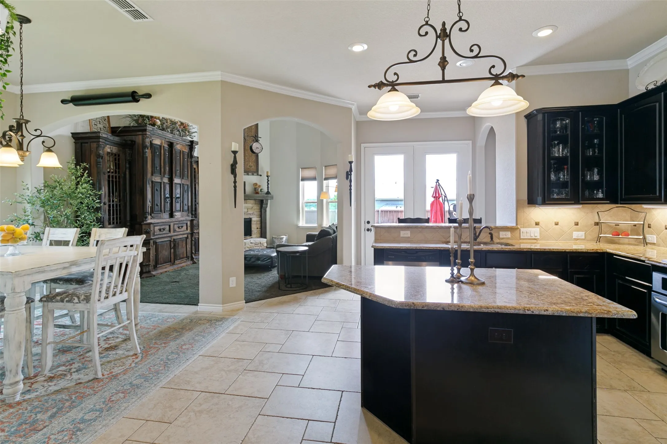 Kitchen featuring dark cabinetry, a center island with a stone countertop, and tile flooring
