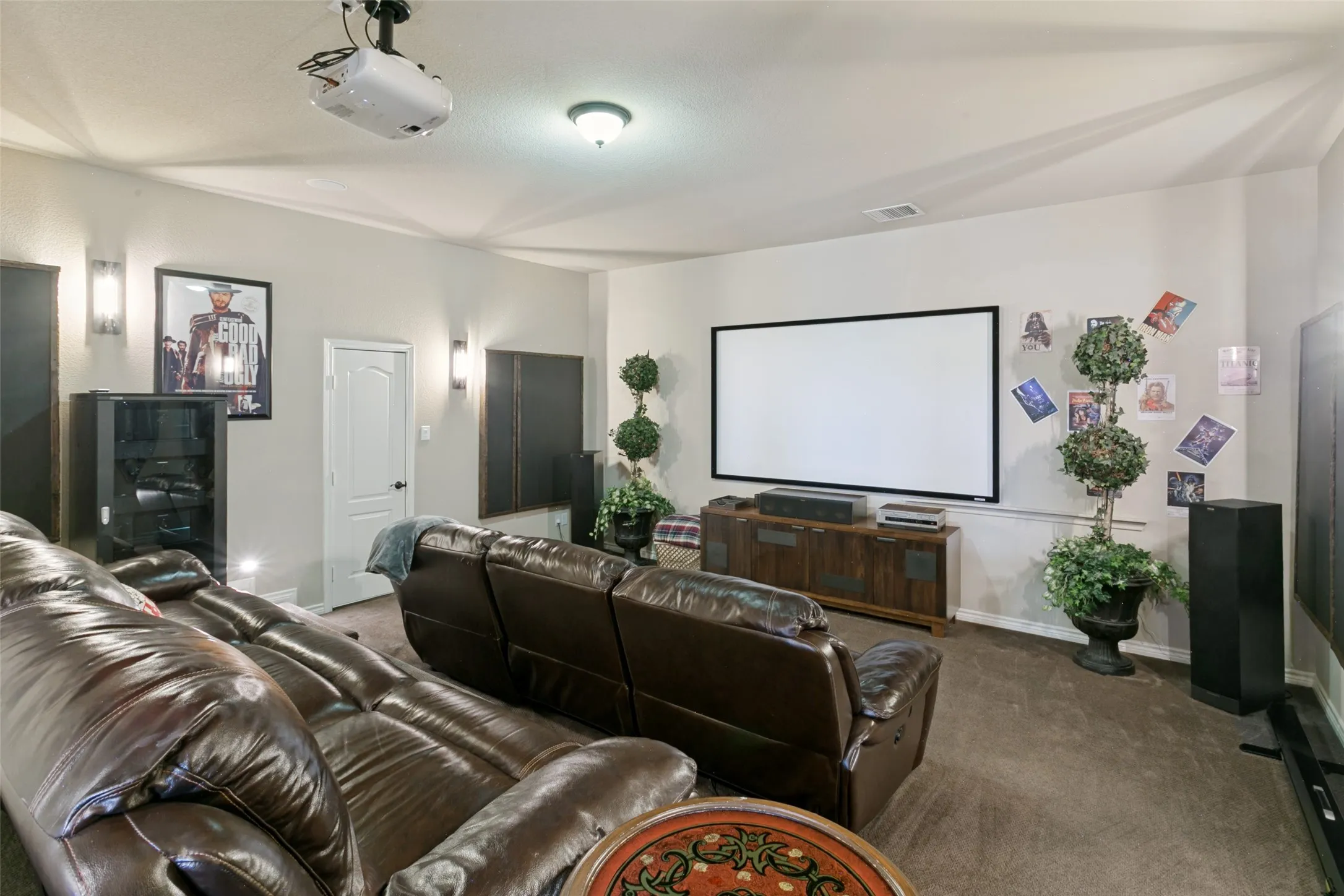 Dedicated stair-stepped Media room featuring a large projection screen, projector, specialized lighting package and atmos sound.