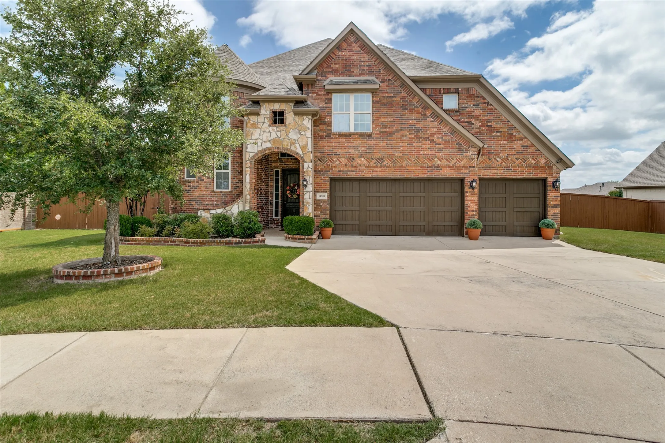 Stunning two-story brick residence with a three-car garage, arched entry portico, and expansive front elevation