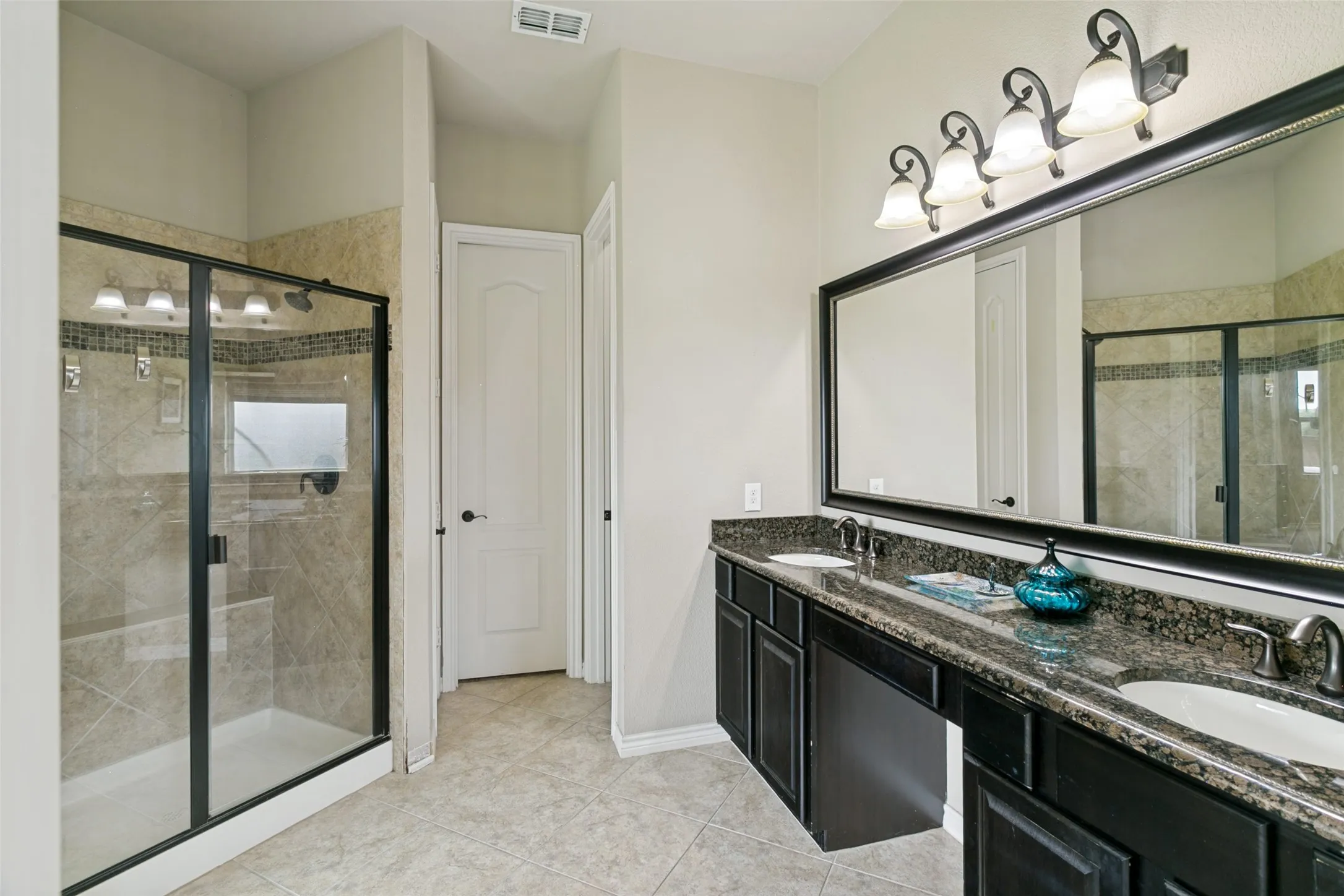 Dual vanity with dark cabinetry and granite-style countertop