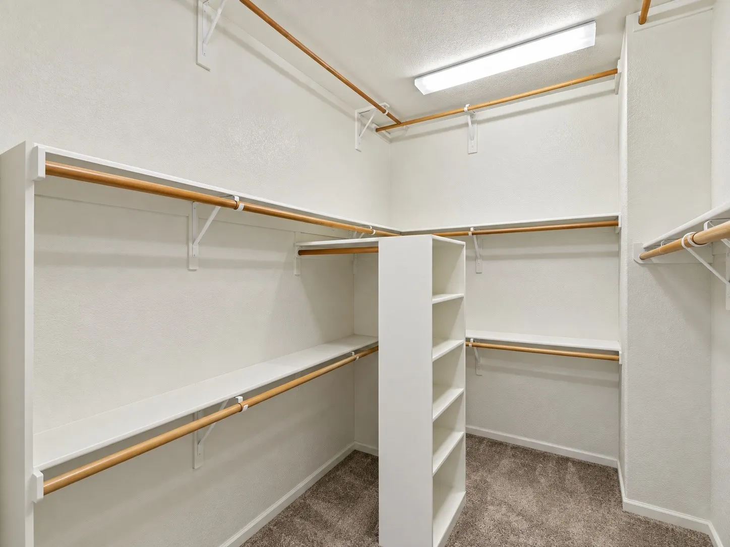 Huge Primary Closet -Built-in shelving, multiple hanging rods, and an integrated storage unit