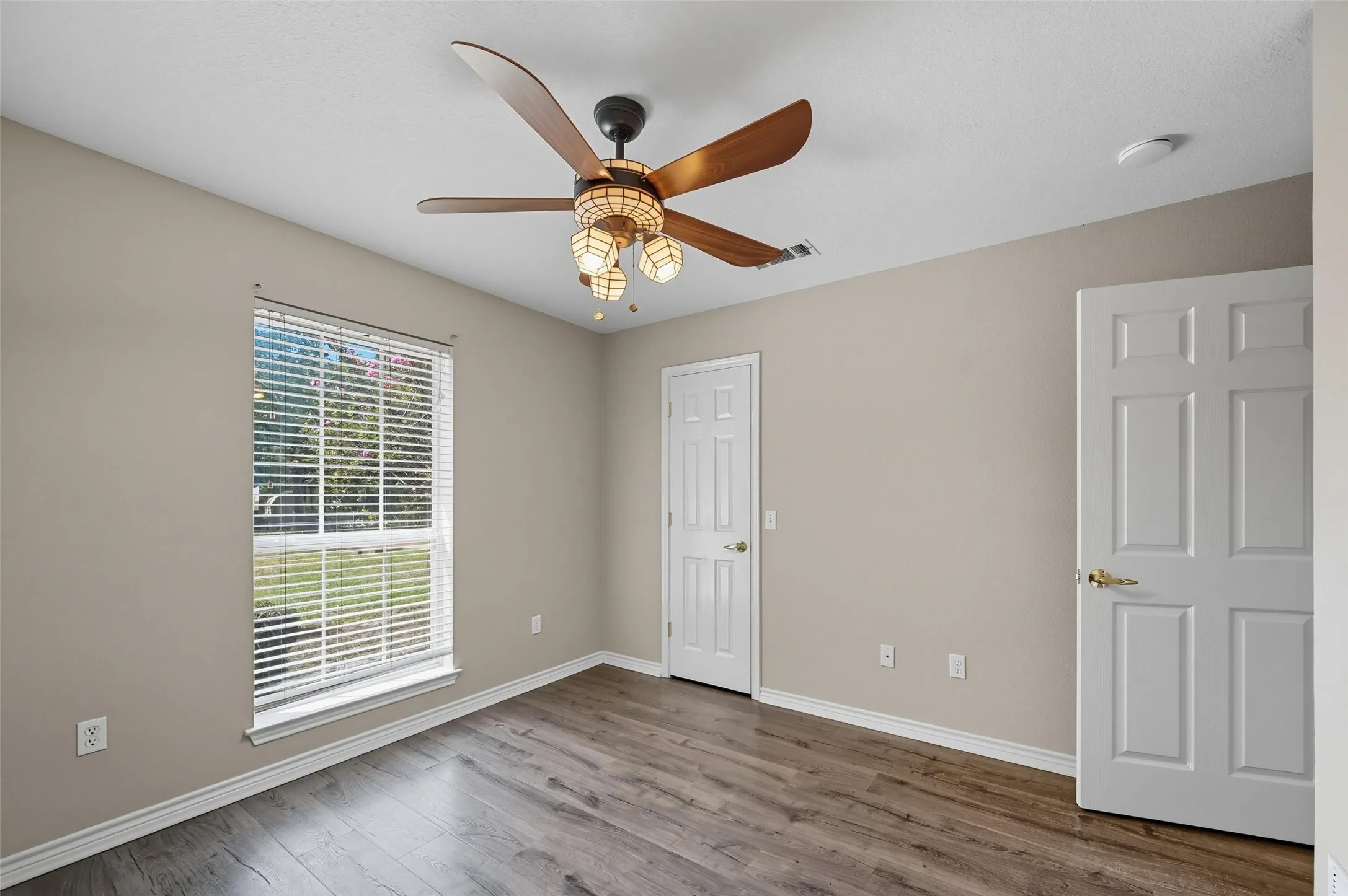 Unfurnished bedroom featuring wood finished floors and a ceiling fan