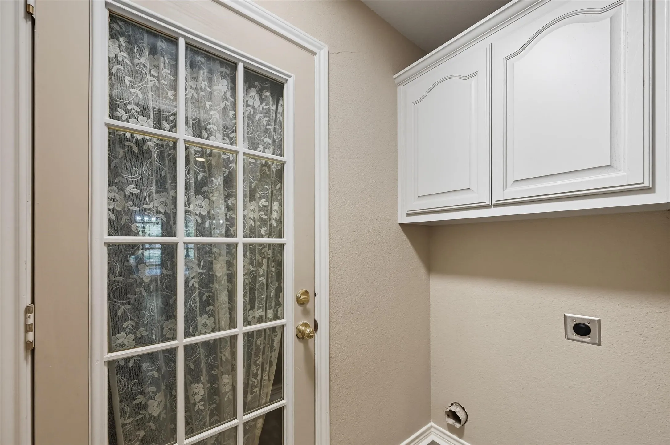Laundry room featuring hookup for an electric dryer, cabinets for storage