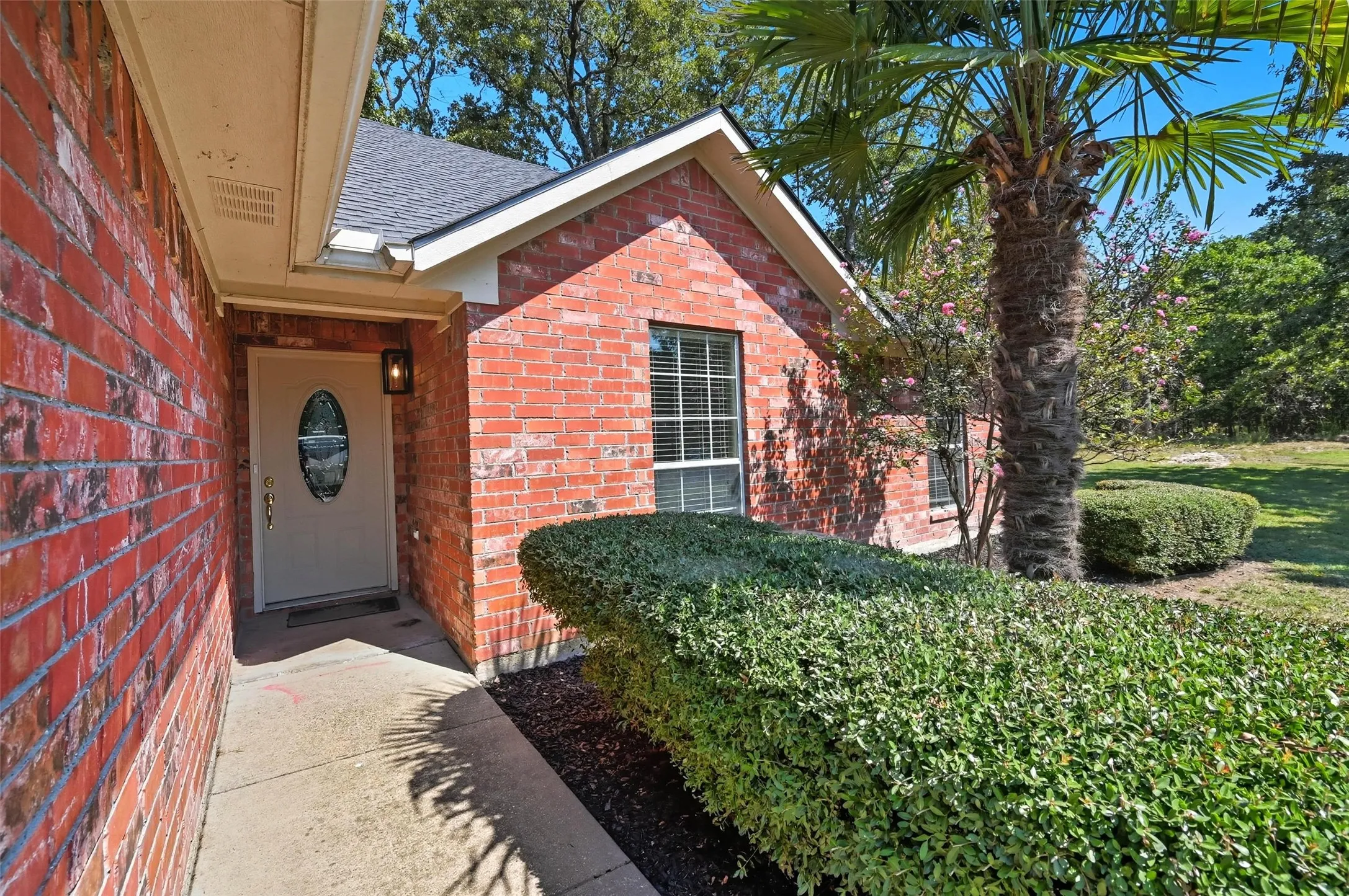 Property entrance with brick siding and a shingled roof