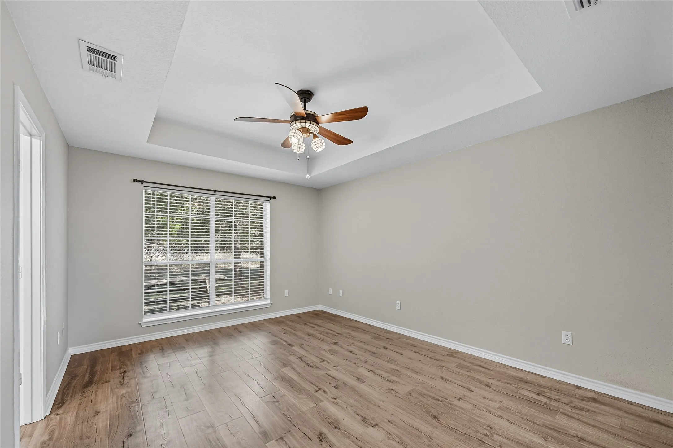 Tray ceiling with windows looking out into the back yard & woods