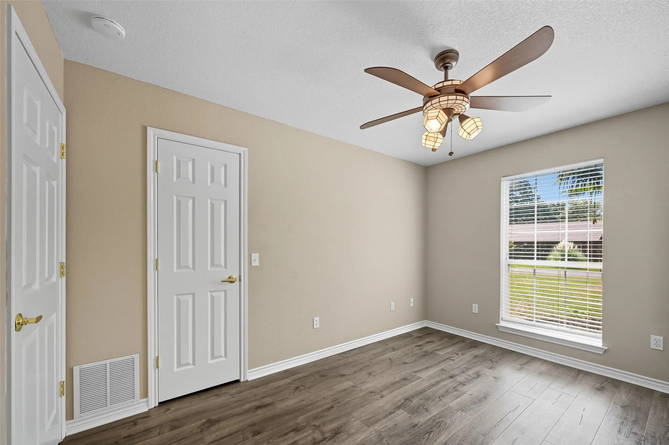 Unfurnished bedroom with wood finished floors, a ceiling fan, and a textured ceiling