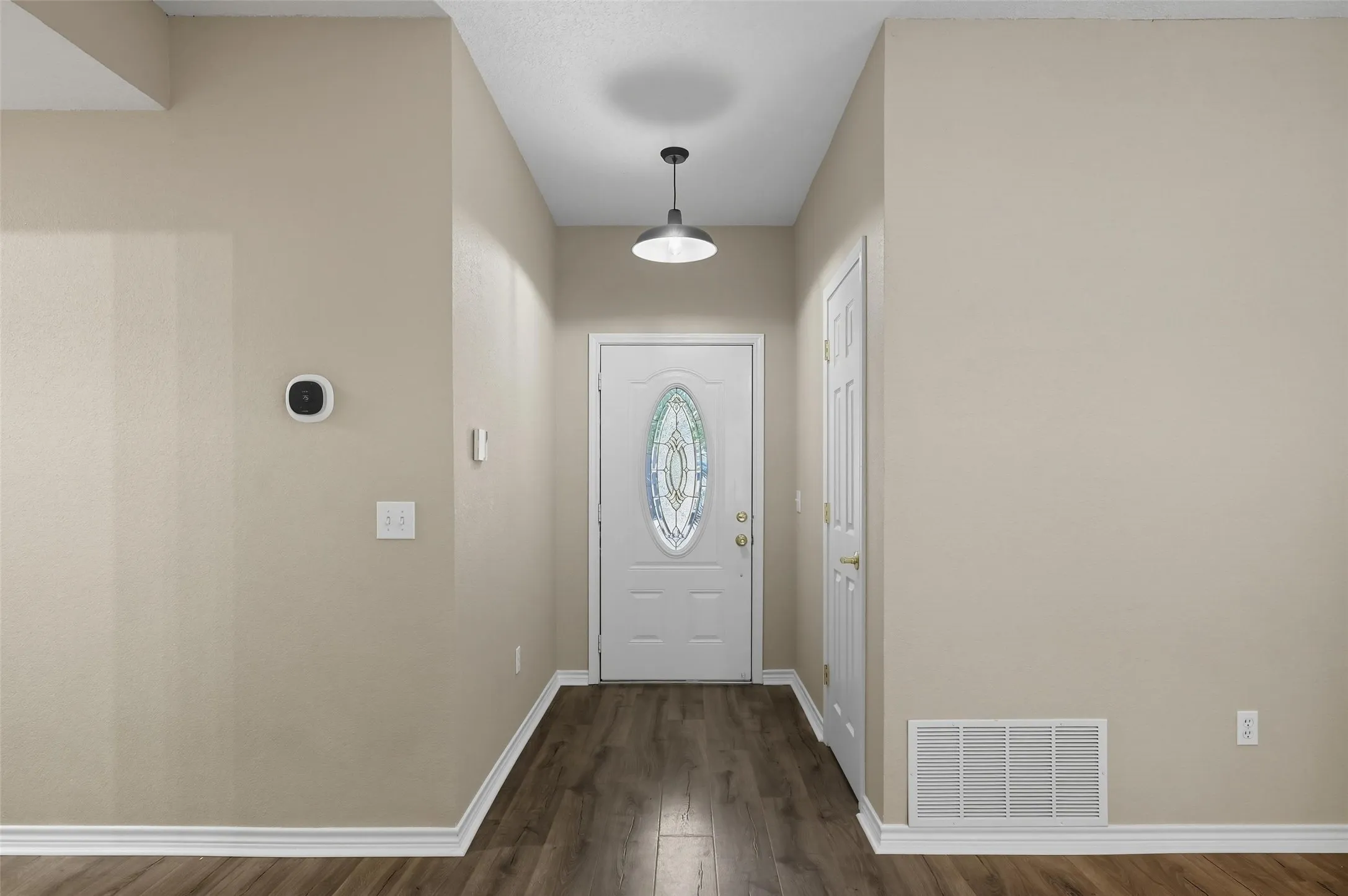 Entrance foyer featuring dark wood-style flooring and baseboards