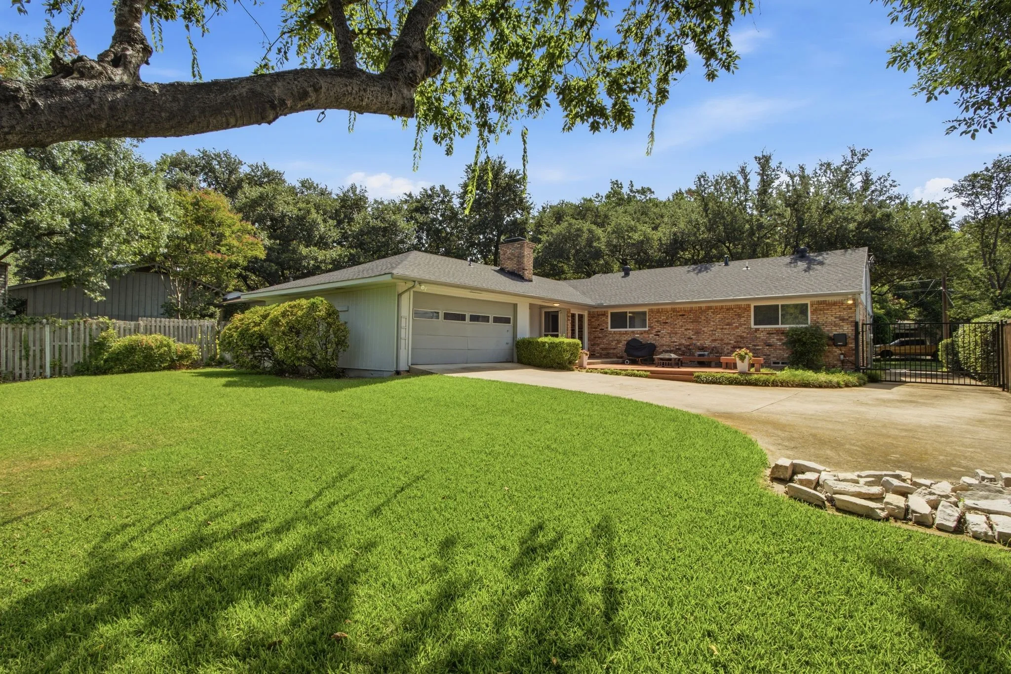 Expansive front lawn with a curved concrete driveway