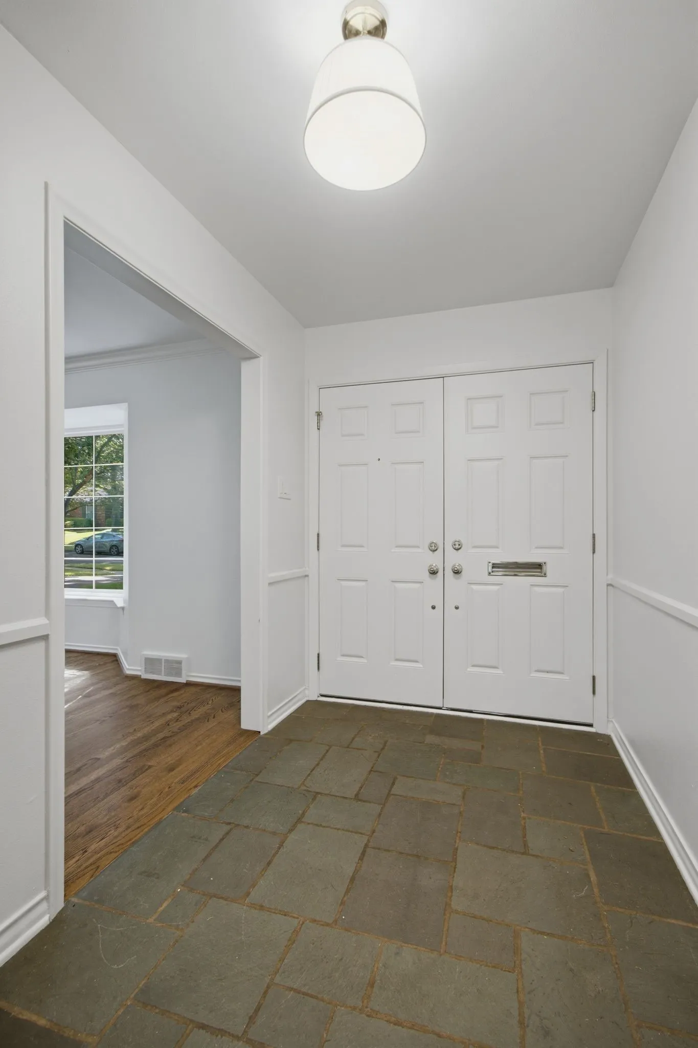 Entry foyer featuring natural stone tile flooring,