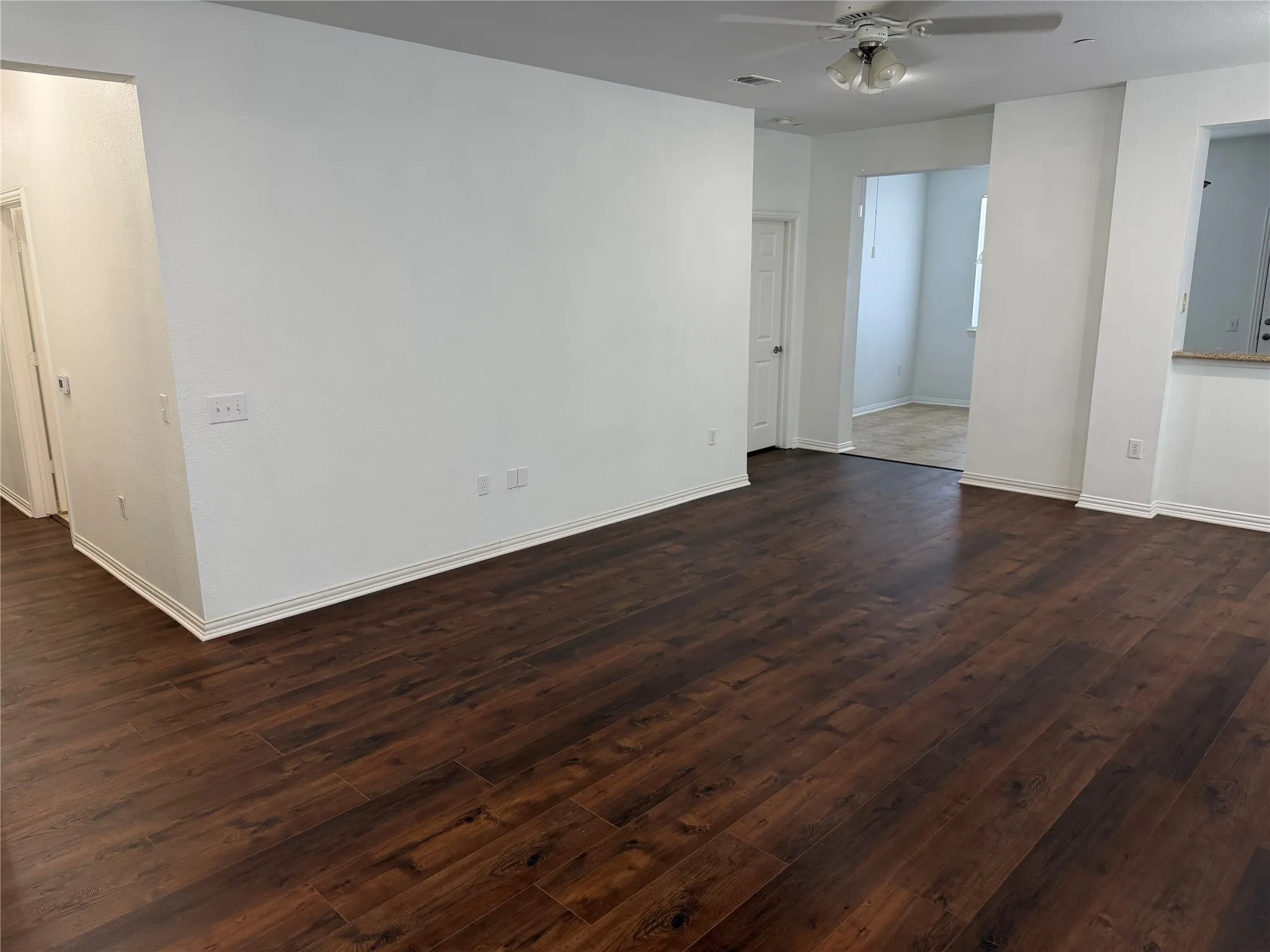 Living area with kitchen on right and guest hallway to the left