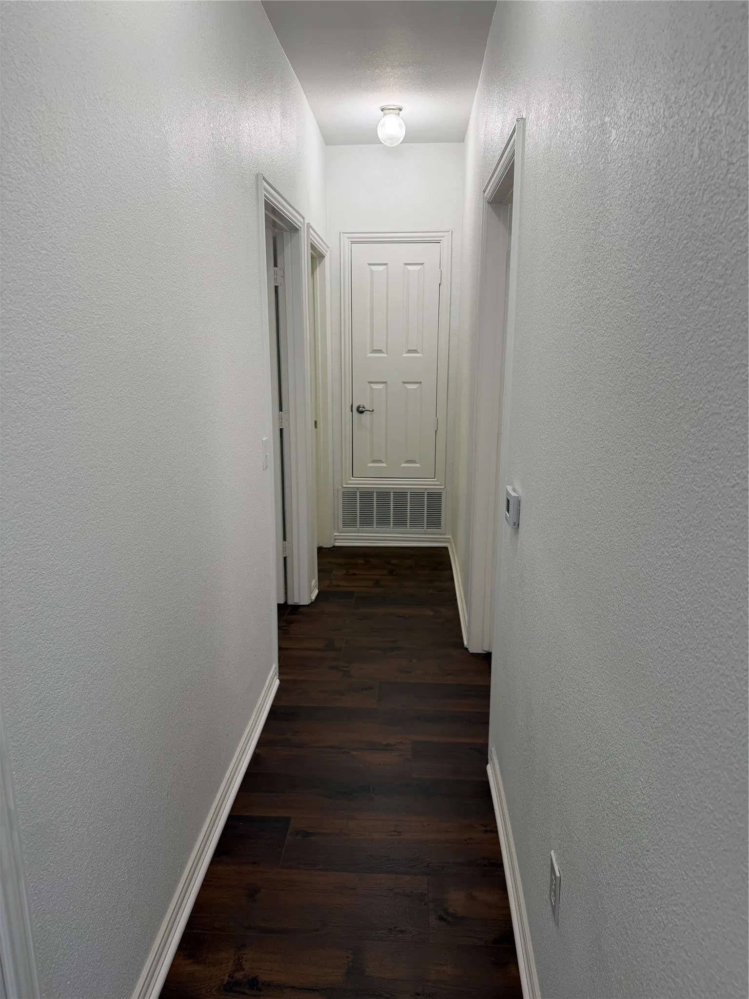 Guest hallway from living area with bathroom on right and bedroom on left.
