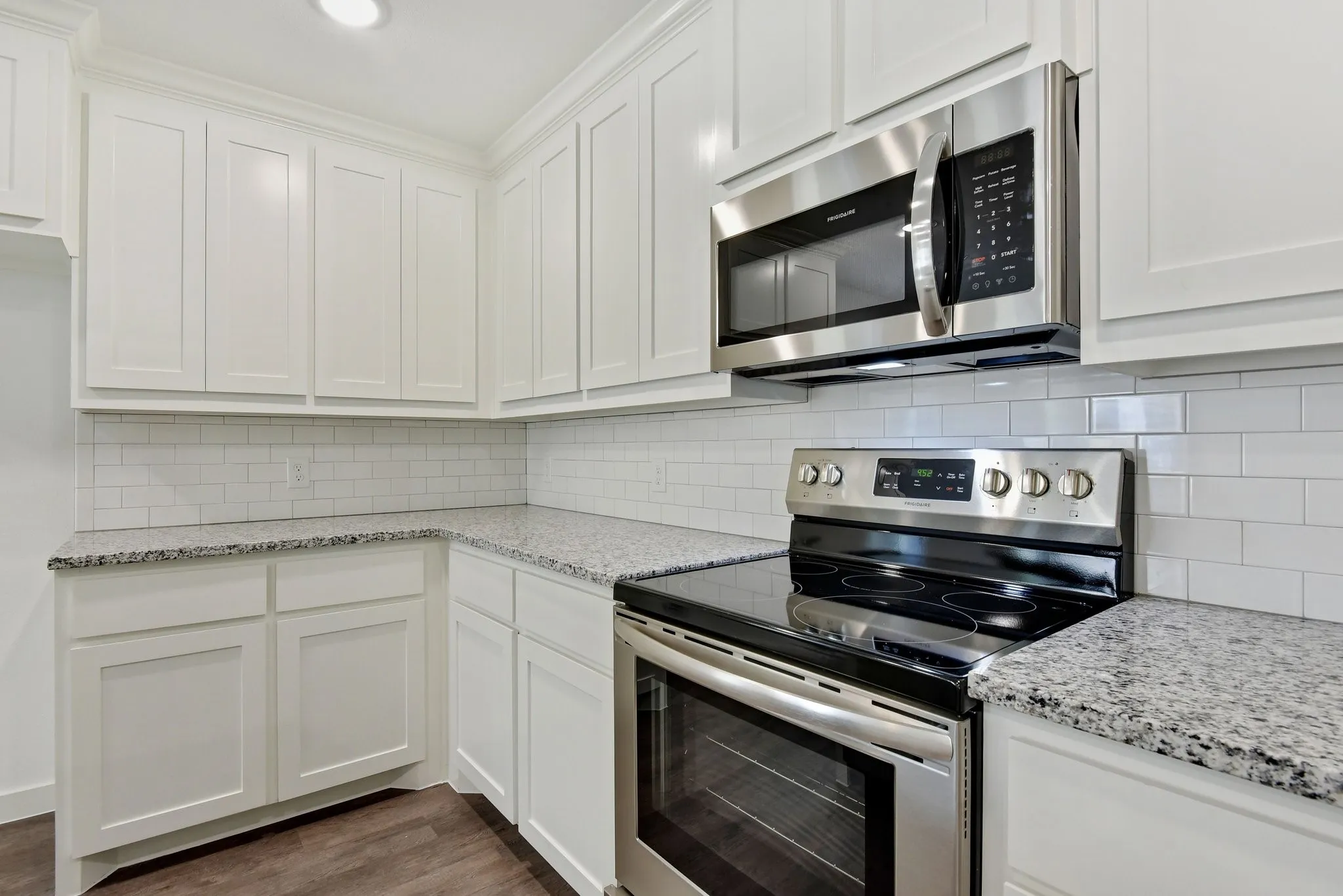Kitchen featuring appliances with stainless steel finishes, tasteful backsplash, white cabinets, and recessed lighting
