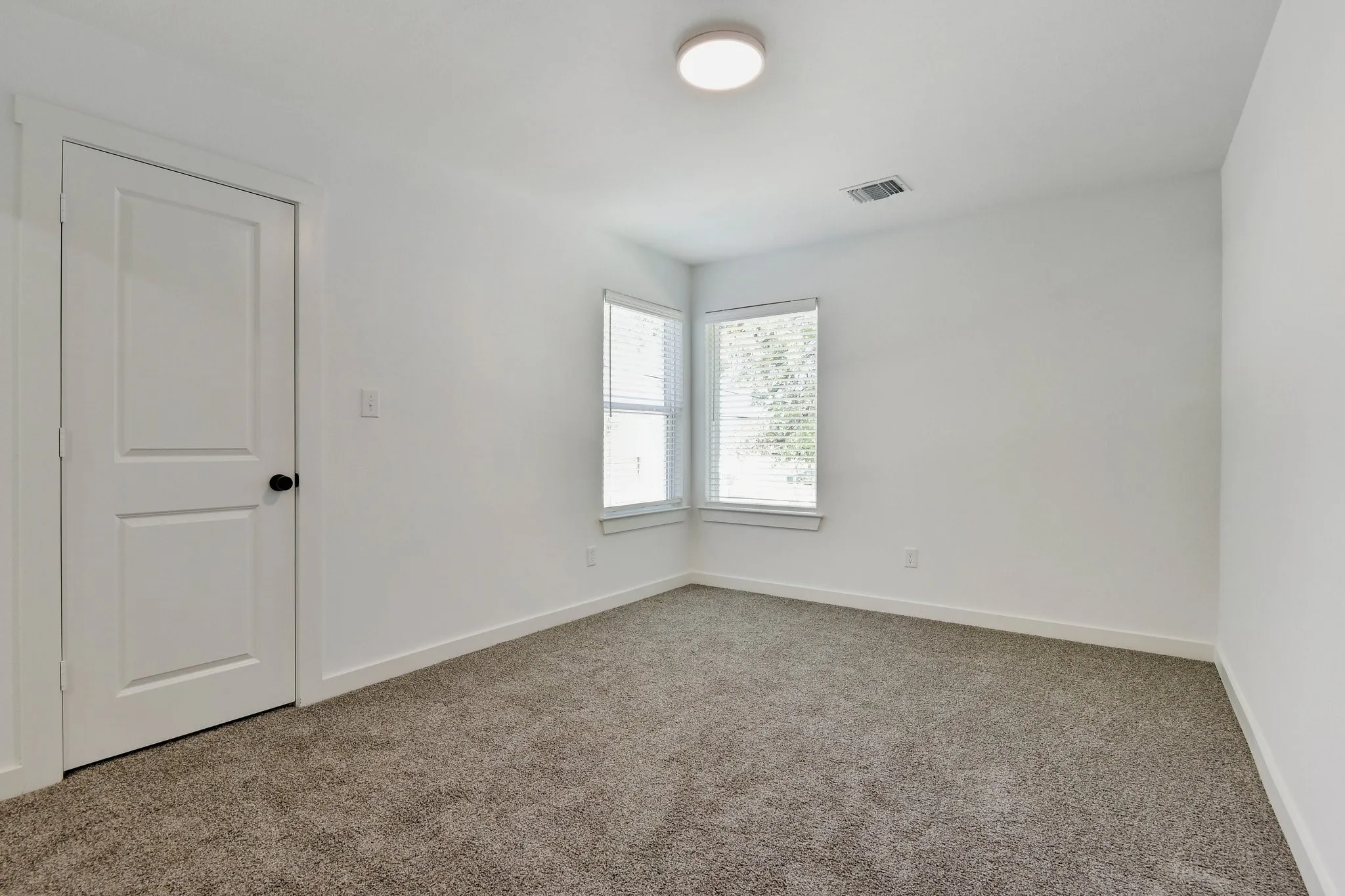 Spare room with light colored carpet and baseboards