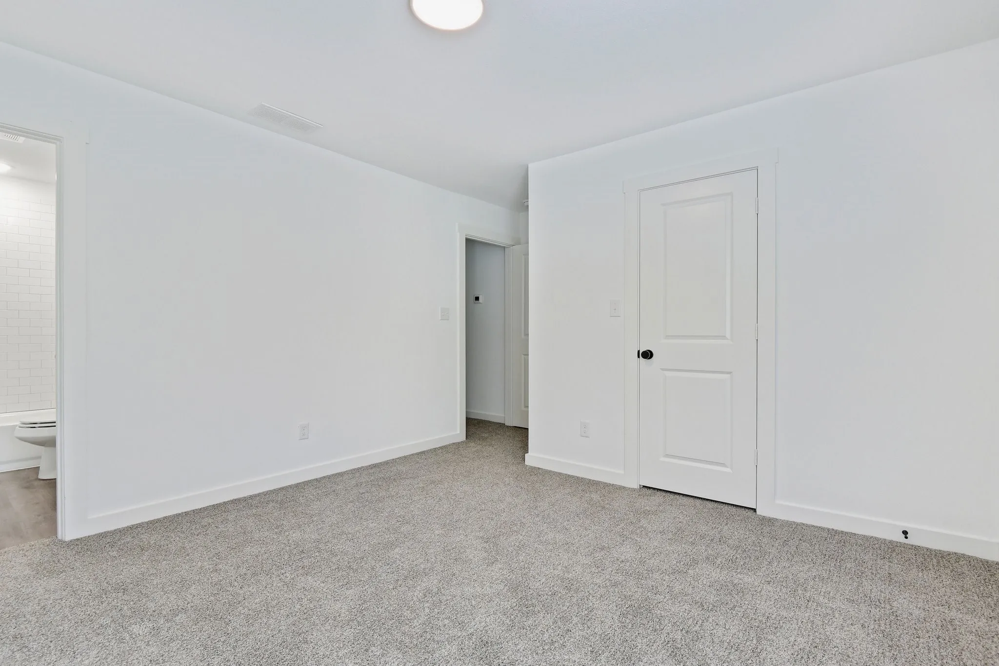 Unfurnished bedroom featuring carpet floors and connected bathroom
