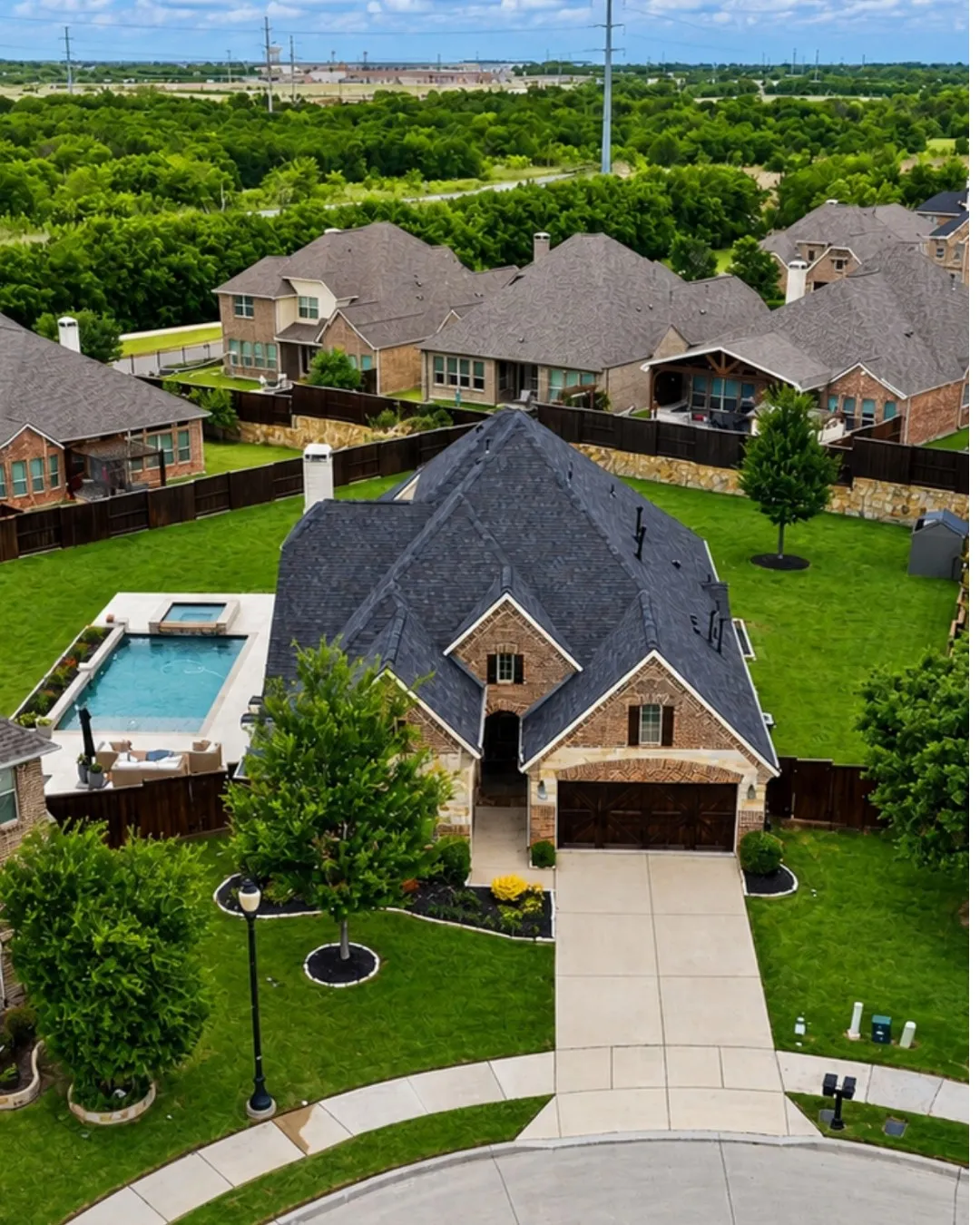 Elegant brick and stone Colonial featuring a steeply pitched architectural roof with multiple gables