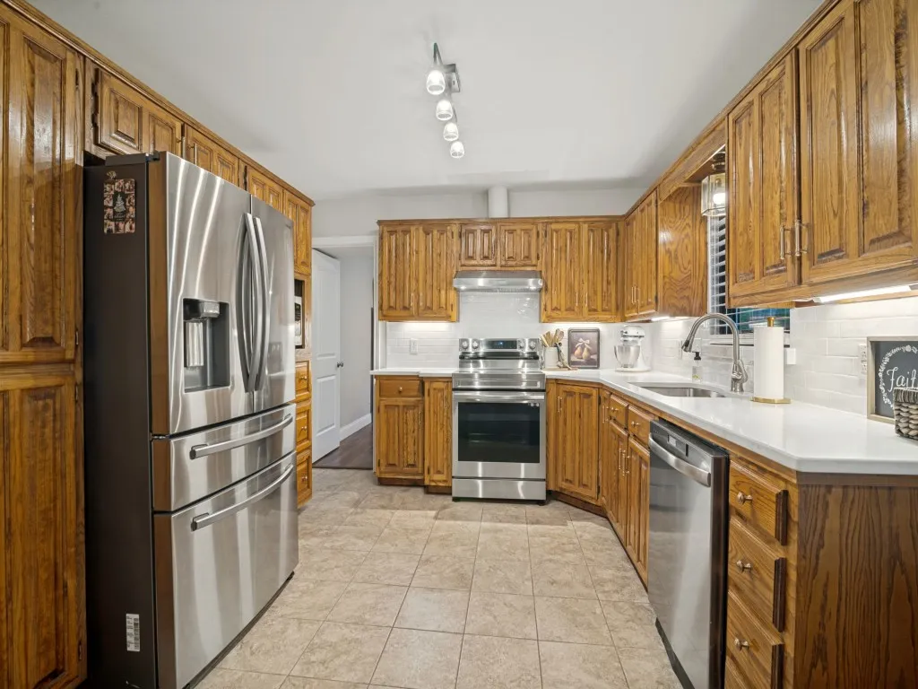Spacious kitchen has quartz counter tops, lots of storage space and stainless appliances.