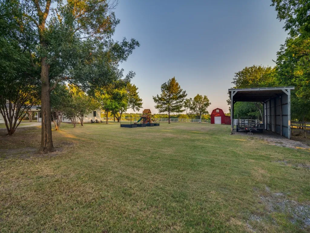 View from the NW corner.  Plenty of front yard to use.  Tall RV storage, barn with fenced in area behind it, with a loafing shed are along the west fence line.  The 16 x 20 gambrel roof, red barn has electricity, an upper level storage area and a water​​‌​​​​‌​​‌‌​‌‌​​​‌‌​‌​‌​‌​​​‌​​ spicket.