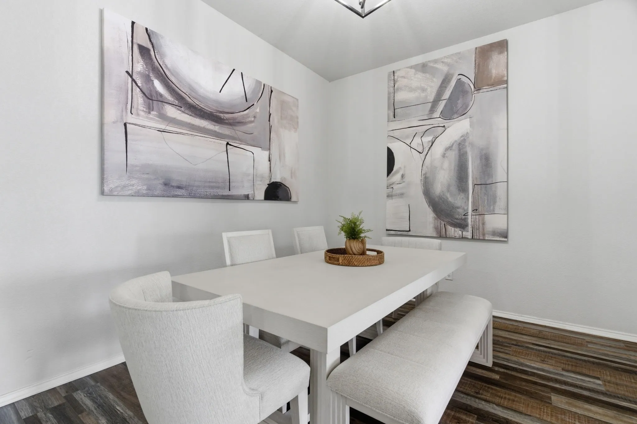 Dining area featuring wood-finish flooring, white walls, and a contemporary ceiling light fixture