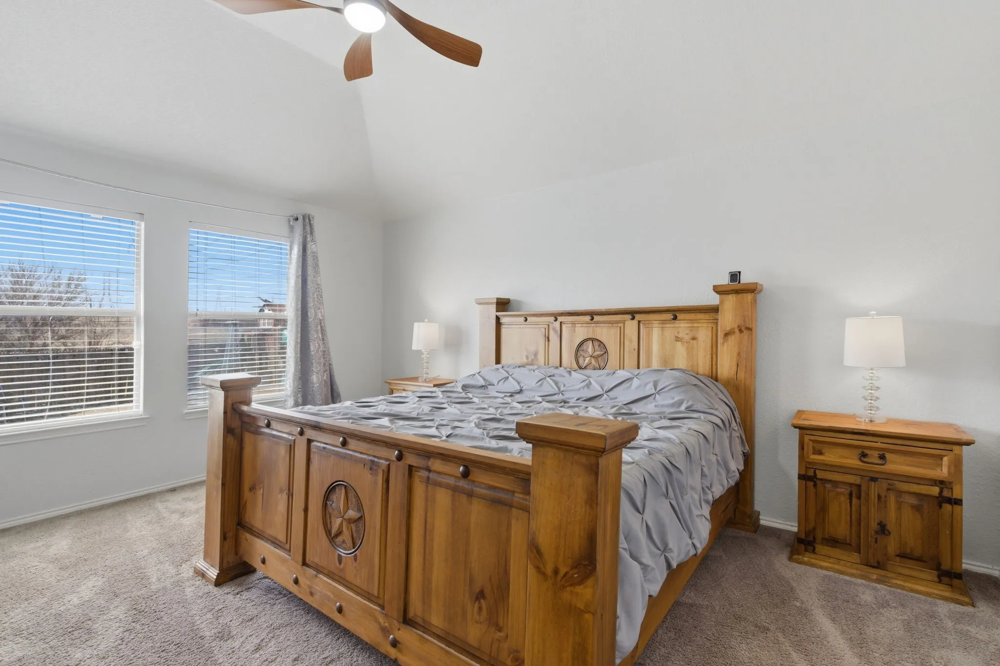 Carpeted bedroom with two windows featuring horizontal blinds