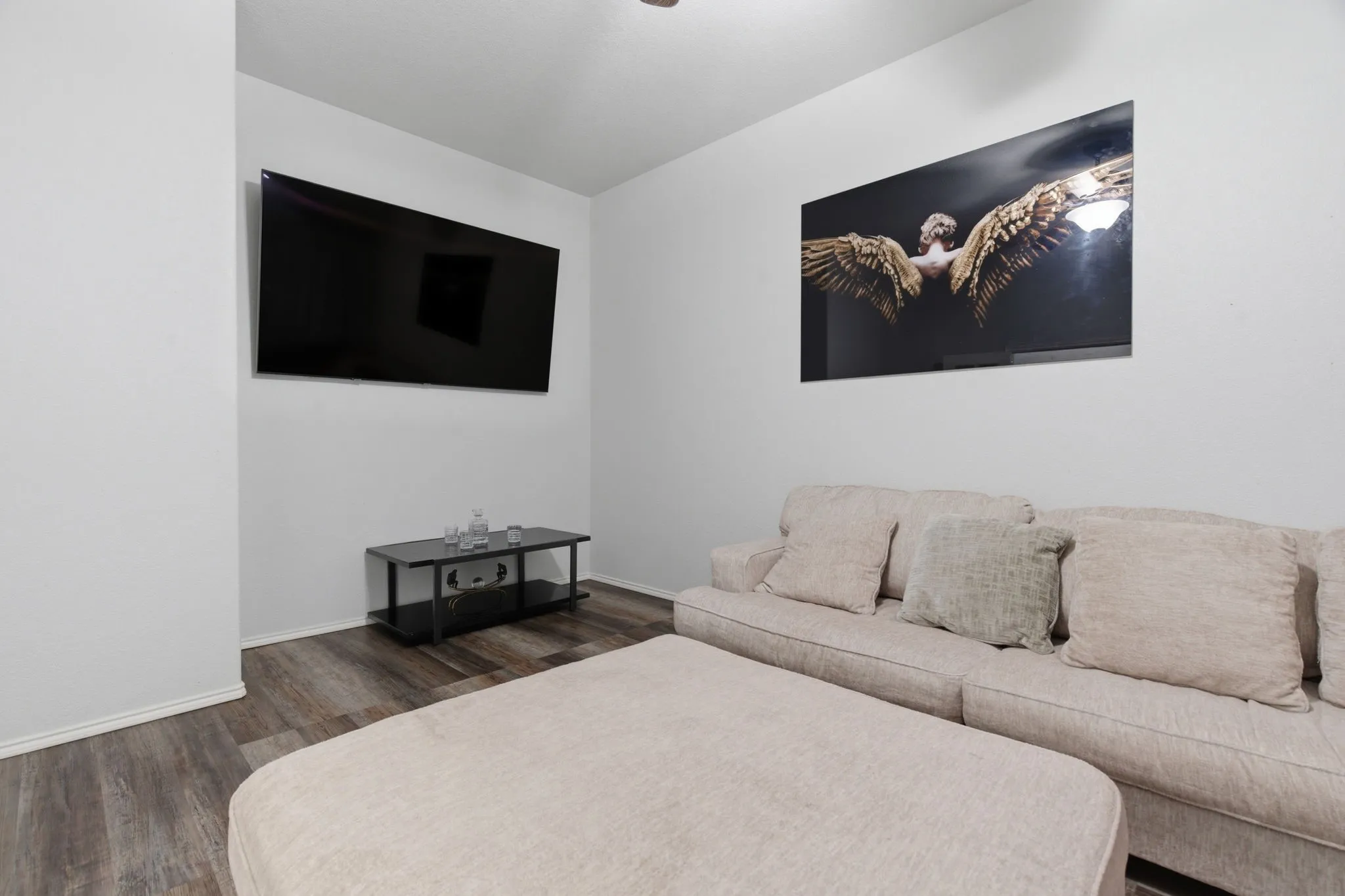 Living area featuring wood-finish flooring, white painted walls, and a recessed ceiling light
