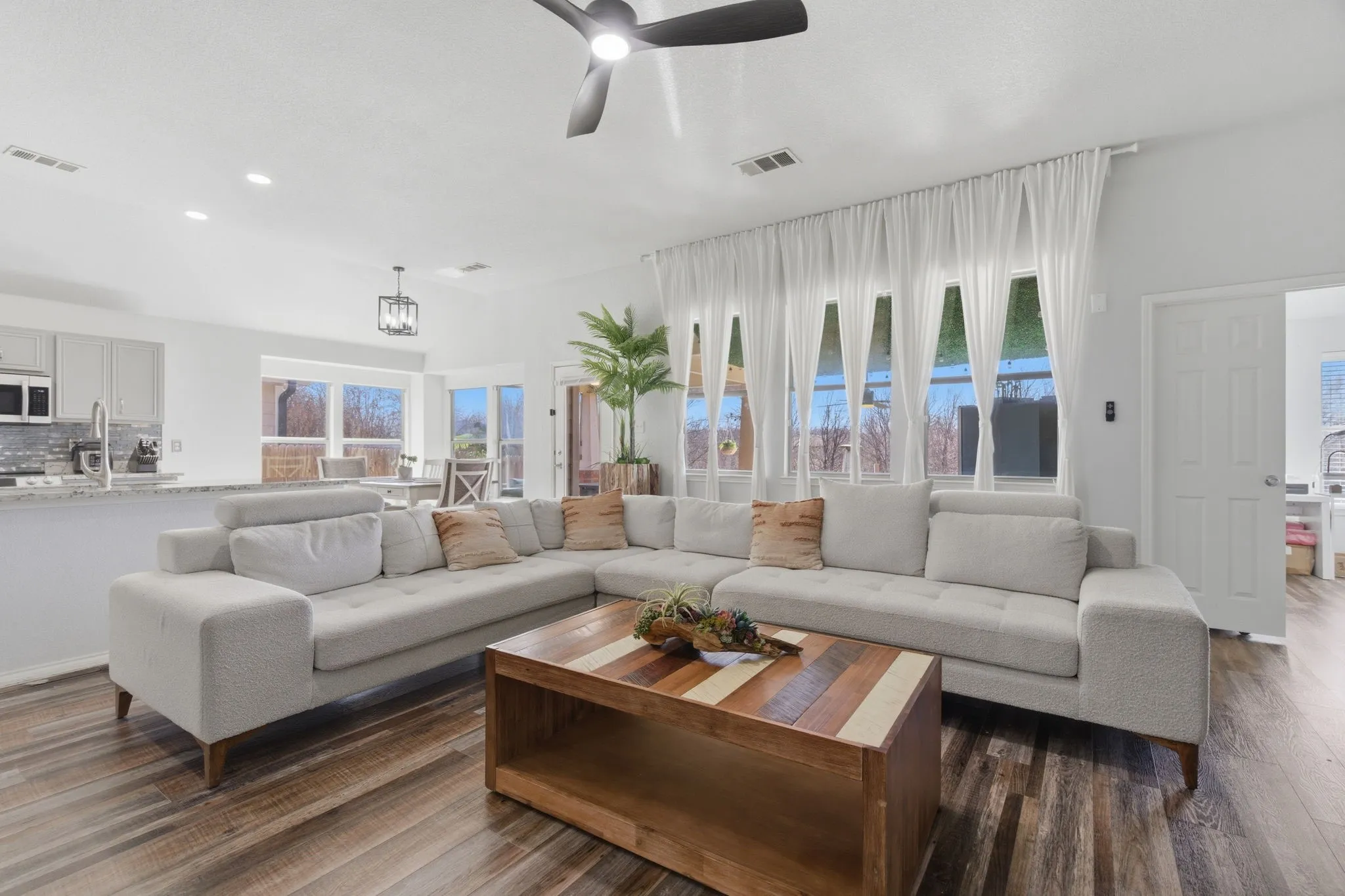 Open-concept living space featuring wood-finish flooring, recessed lighting, and a modern ceiling fan