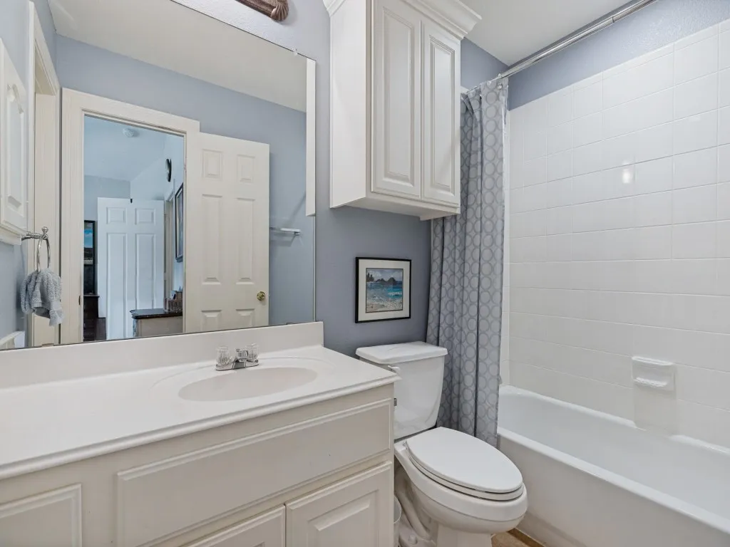 White vanity with integrated sink, chrome-finish faucet, and coordinating upper cabinetry