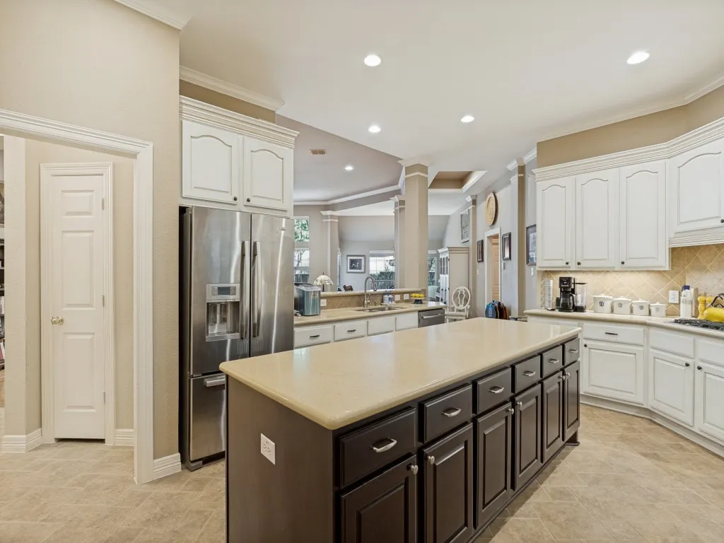 Kitchen featuring a central island with dark wood-finish cabinetry, light-toned countertops, and recessed lighting