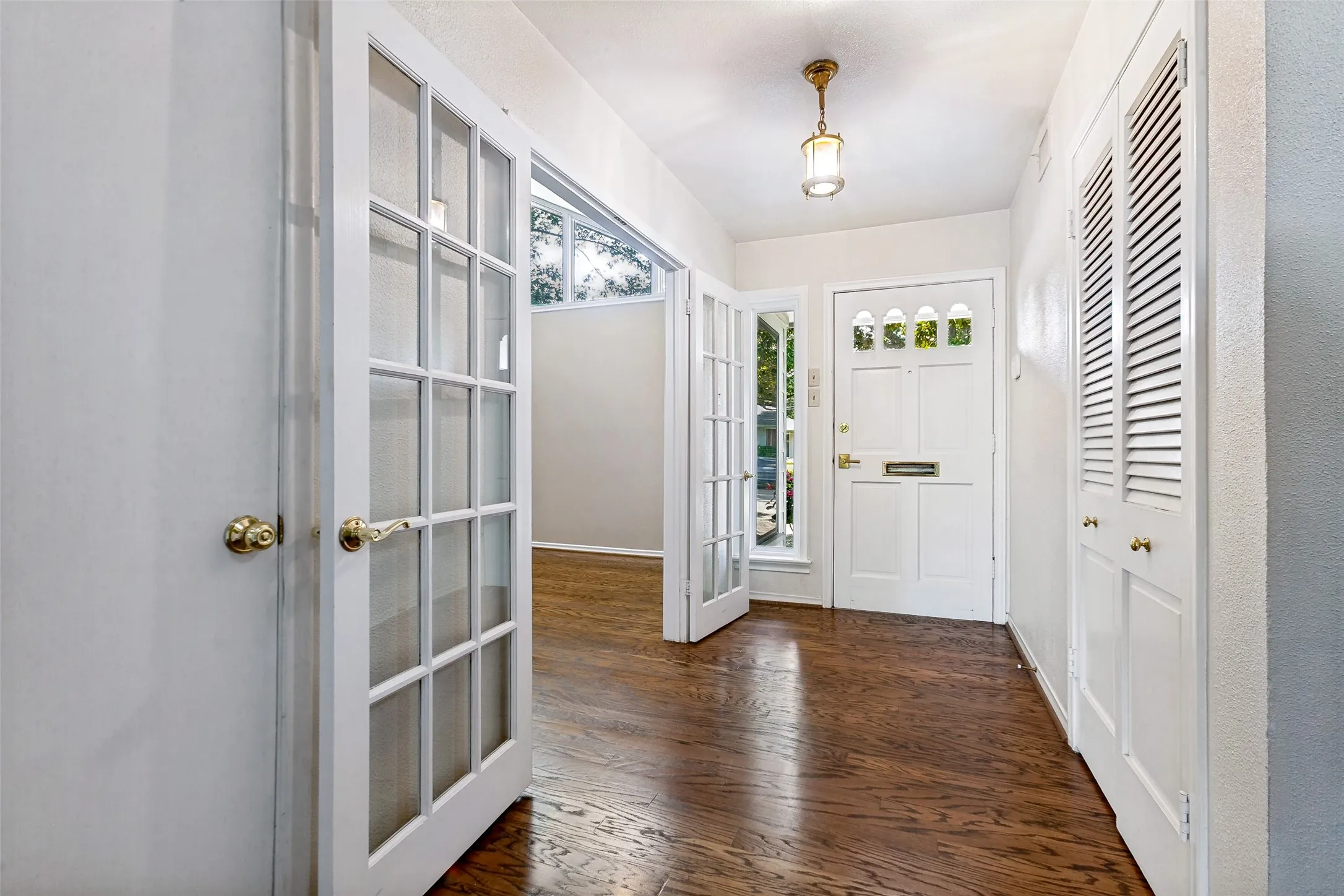 Entryway with french doors leading to the Formal living room and Formal dining area. Beautiful wood flooring.