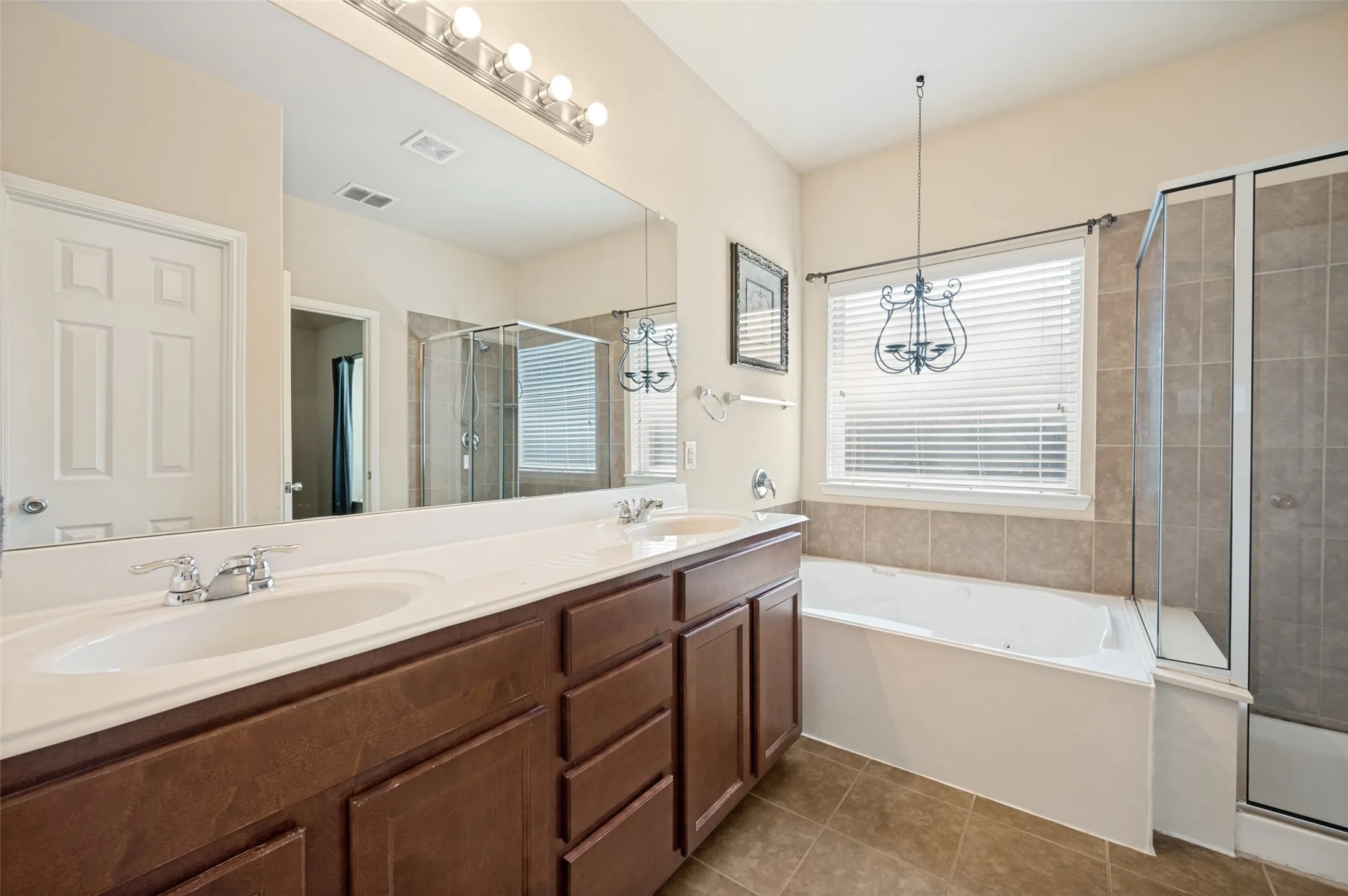 Bathroom featuring a double vanity with white countertops and wood-finish cabinetry