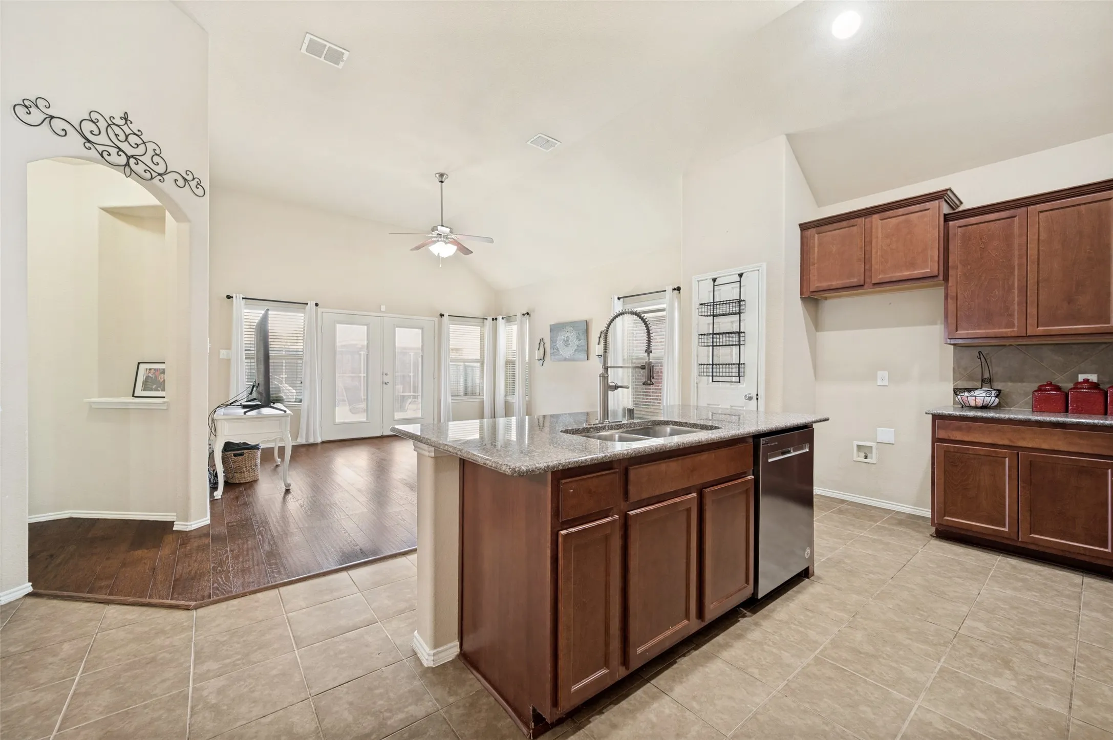 Kitchen island with integrated double basin sink, stainless steel dishwasher, and granite countertop
