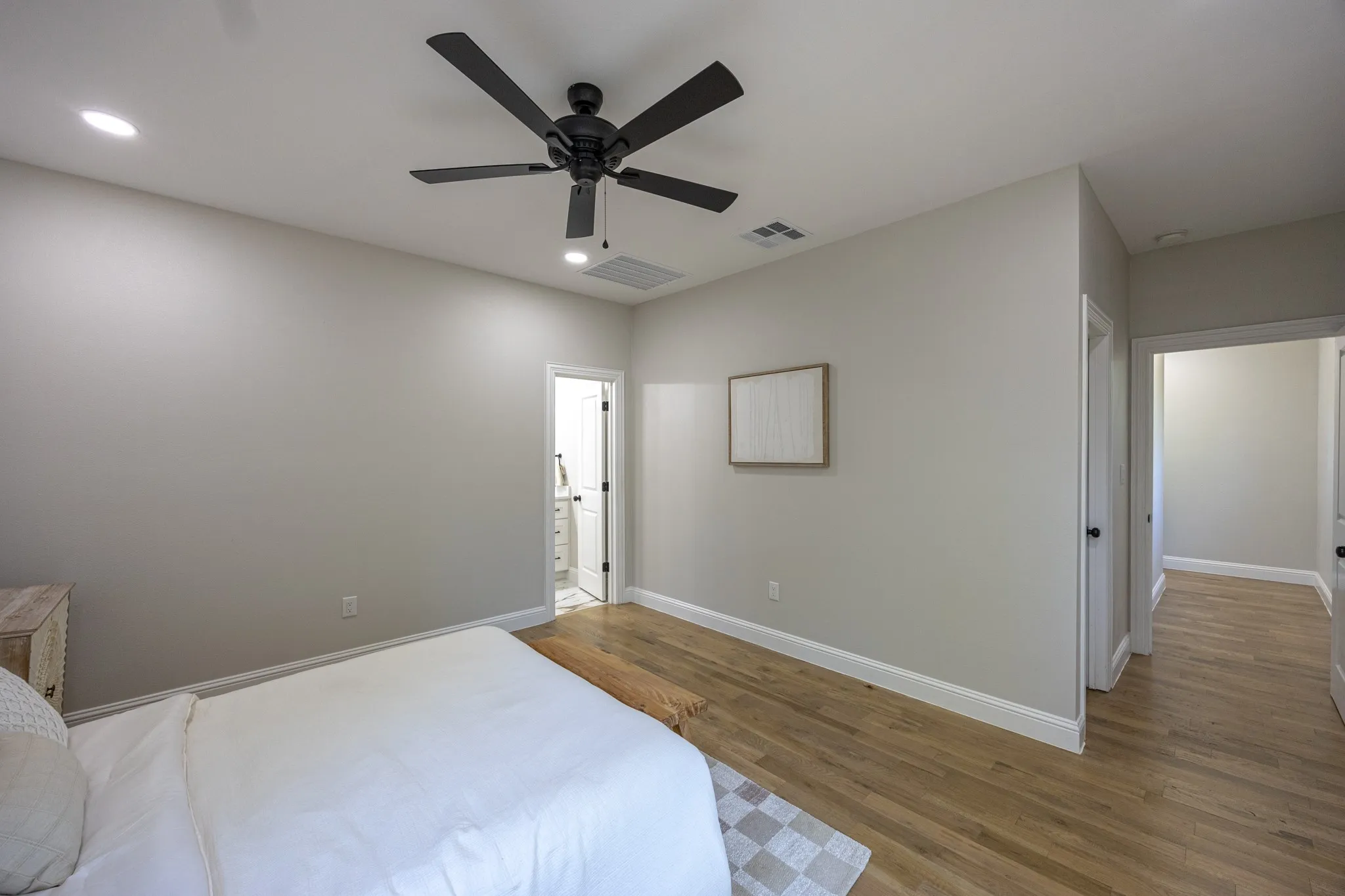 Room featuring wood-finish flooring, recessed lighting, and a contemporary black ceiling fan