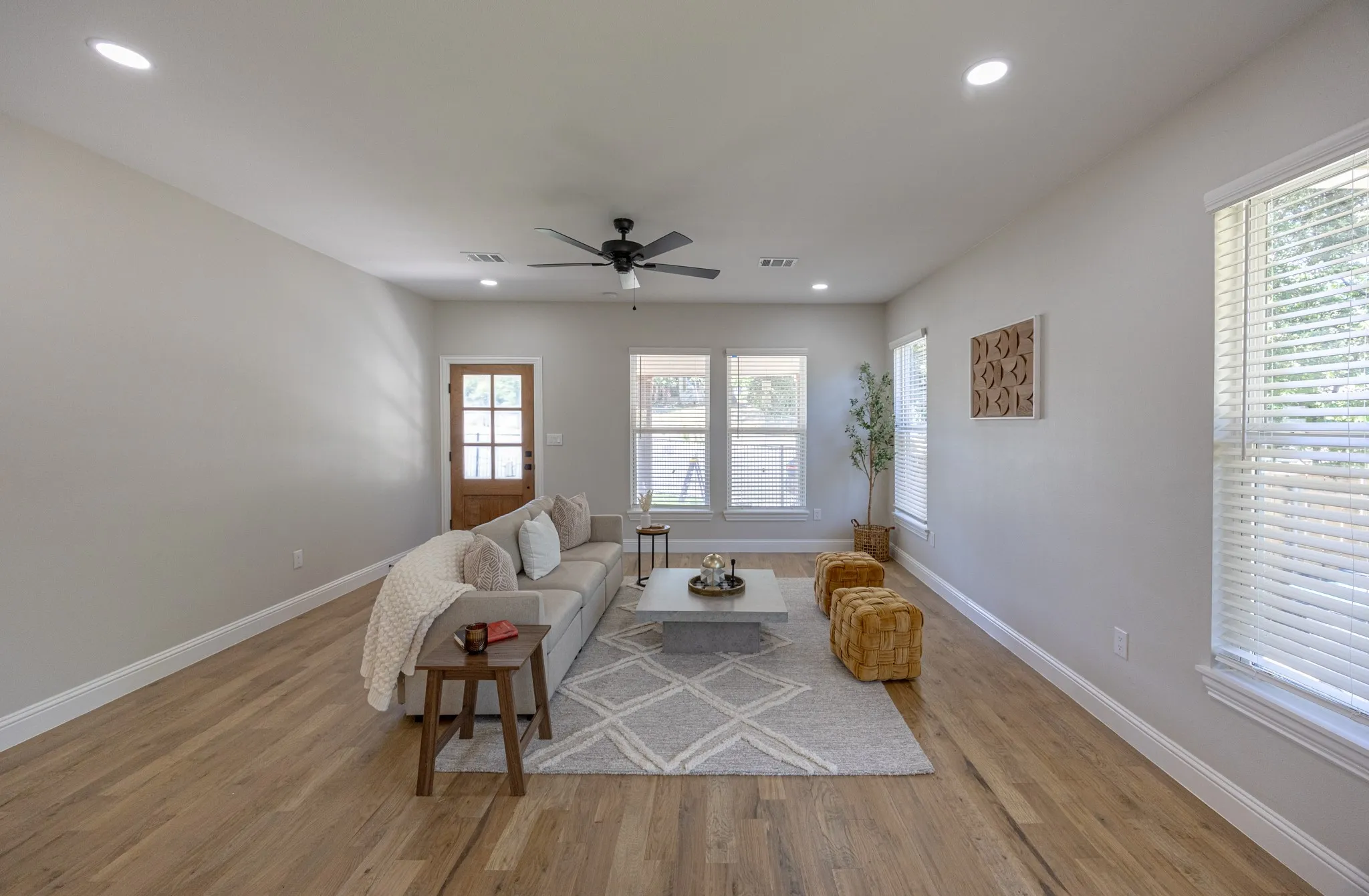 Open-concept living space featuring wood-finish flooring and ample natural light from multiple windows
