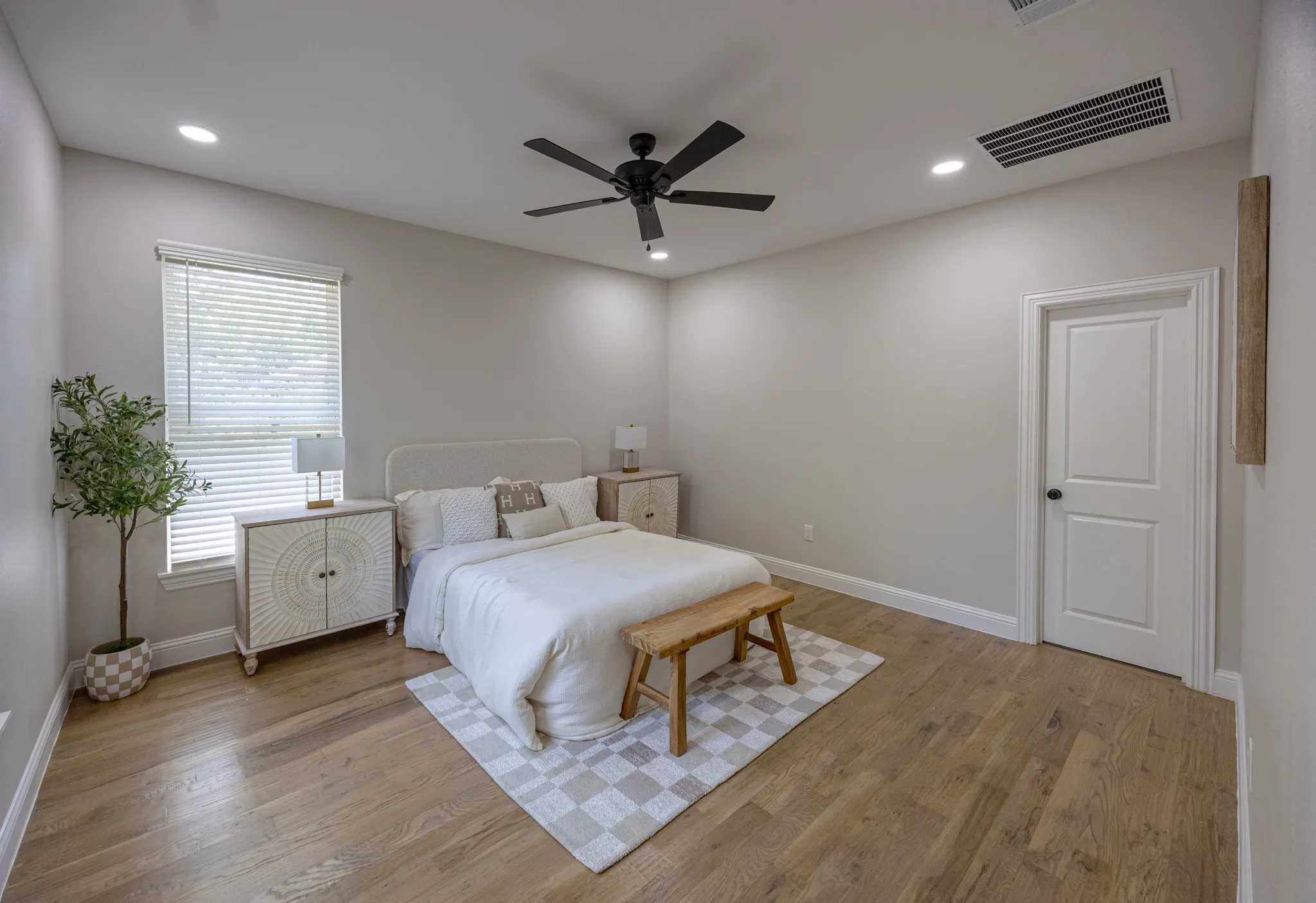 Spacious room featuring wood-finish flooring, recessed lighting, and a modern ceiling fan